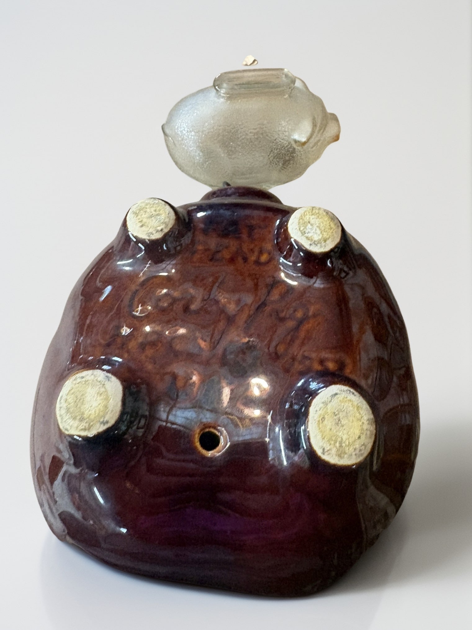 Set of Two Vintage Piggy Banks: This lot features a charming pair of piggy banks, showcasing a delightful contrast in materials and design. The larger bank is crafted from a rich, mottled brown art pottery with a distinctive