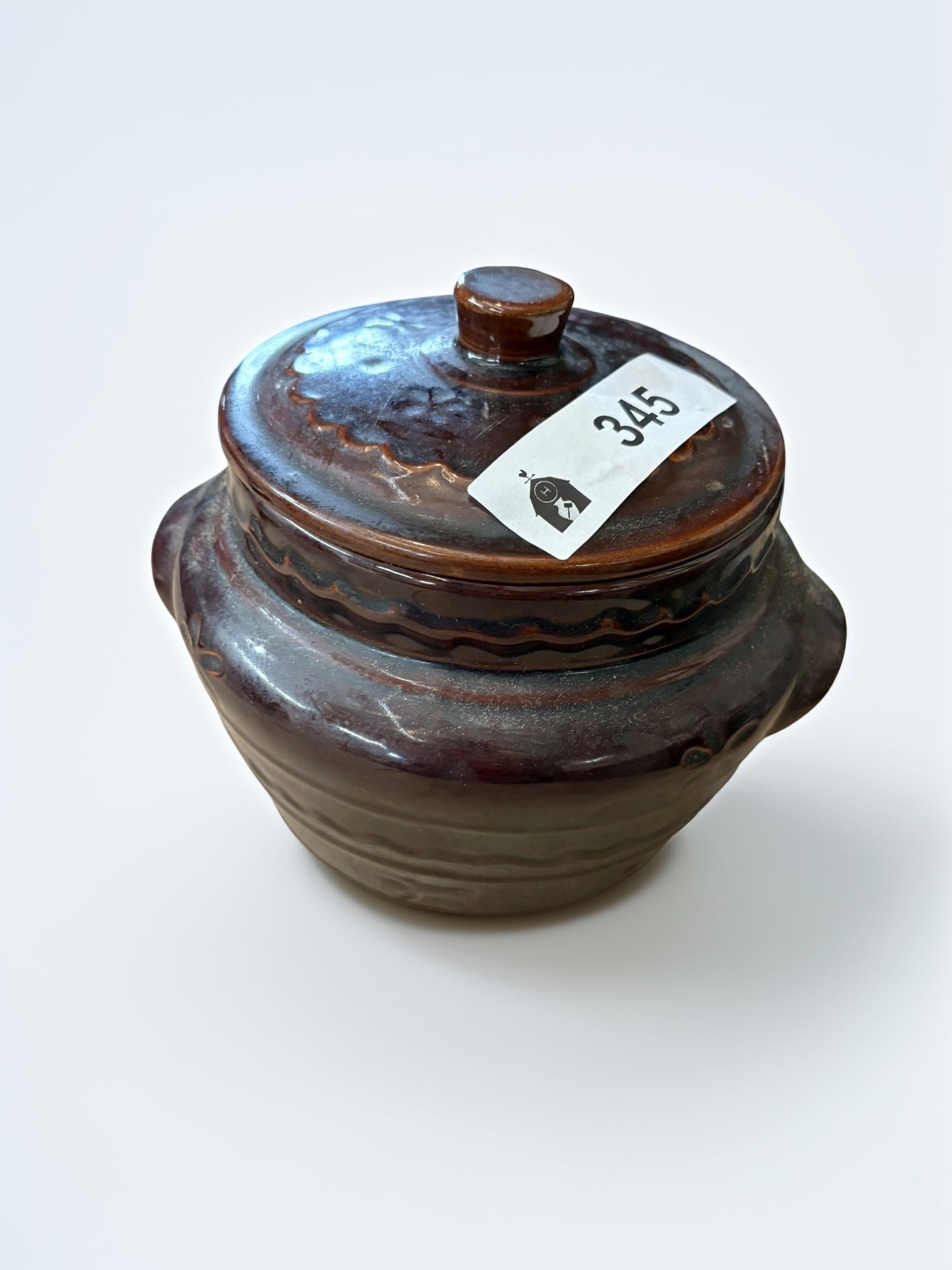 Hull Oven Proof Stoneware Covered Bean Pot: This charming vintage covered bean pot, produced by Hull Pottery, features a rich brown glaze and classic, rustic styling. The pot includes a matching lid with a knob handle and decorative embossed de