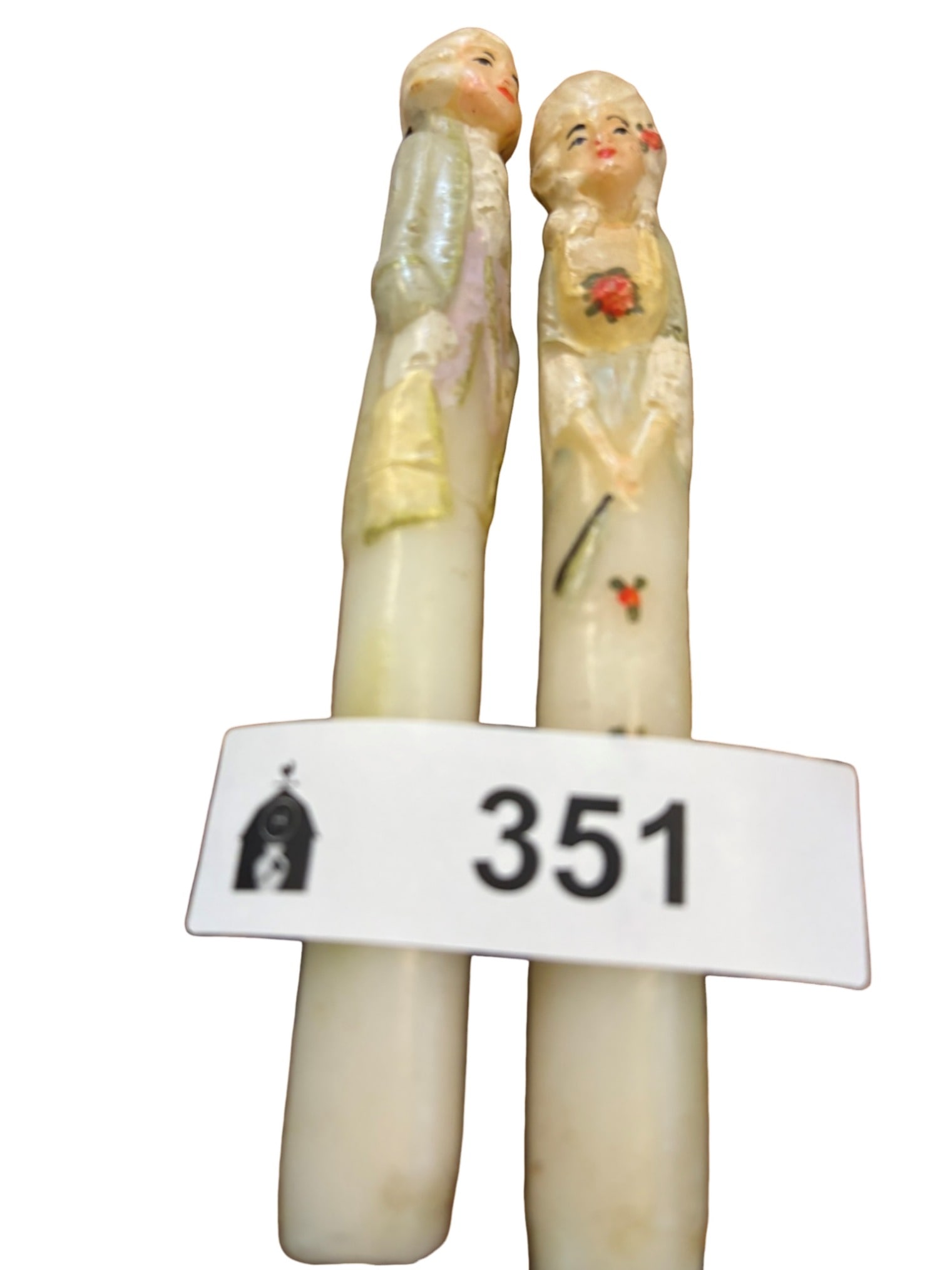 Rare Pair of Figural Colonial-Style Taper Candles: This charming pair of rare vintage taper candles features intricately molded figural depictions of an 18th-century colonial couple. The male figure is dressed in period attire, while the female figure
