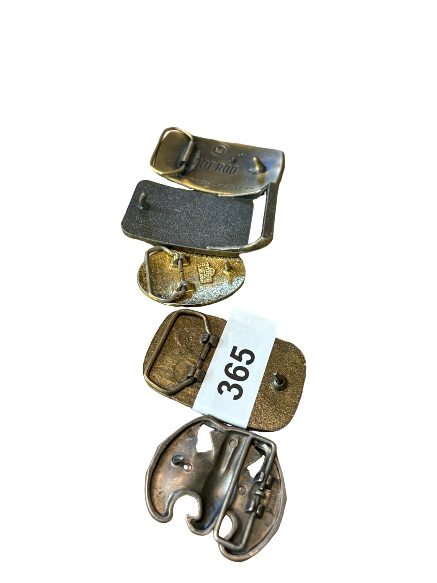 Collection of Five Vintage Assorted Belt Buckles: This eclectic collection features five distinct vintage belt buckles, showcasing a variety of themes including automotive, musical, fraternal, maritime, and patriotic motifs. The set includes a brass-