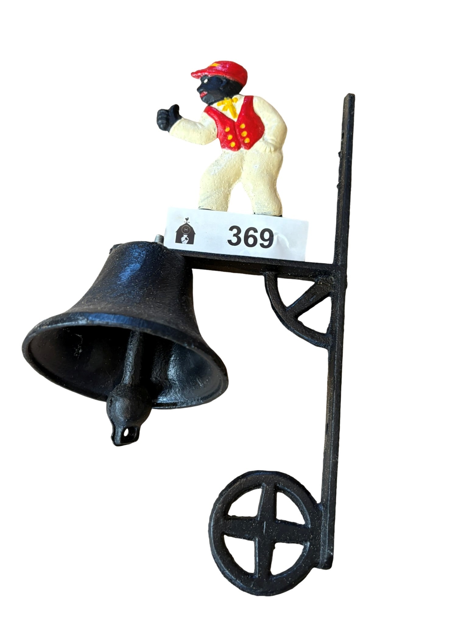 Cast Iron Figural Wall-Mount Doorbell: This decorative cast iron wall-mount doorbell features a painted figural motif of a figure in a red vest and cap perched atop the mounting bracket. The piece is constructed with a sturdy metal backpla