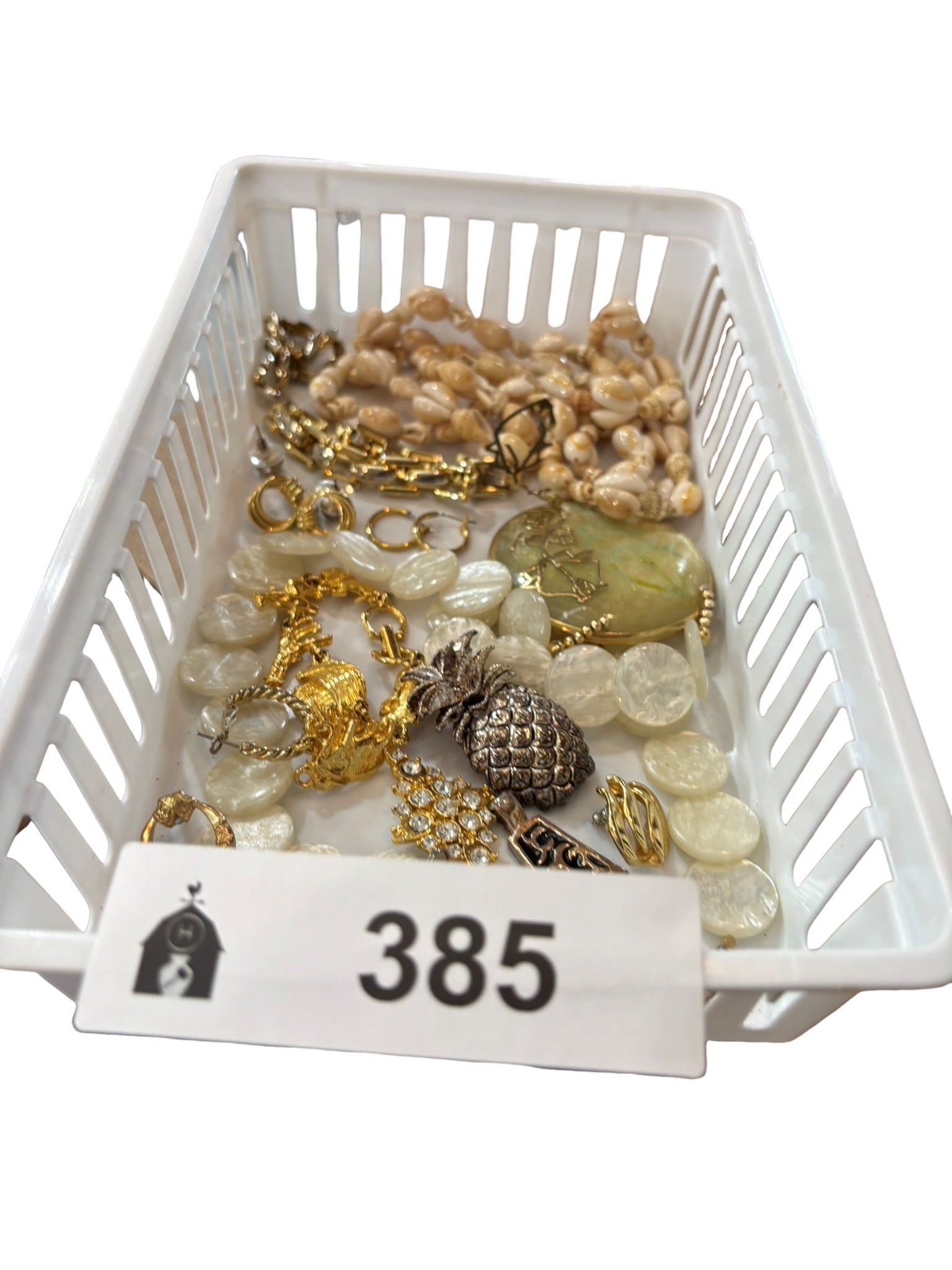 Assorted Vintage Fashion Jewelry Collection: This lot features a diverse collection of vintage fashion jewelry, including necklaces, earrings, and pendants. Highlights include a shell-accented chain, a pineapple-shaped pendant, a large stone-sty