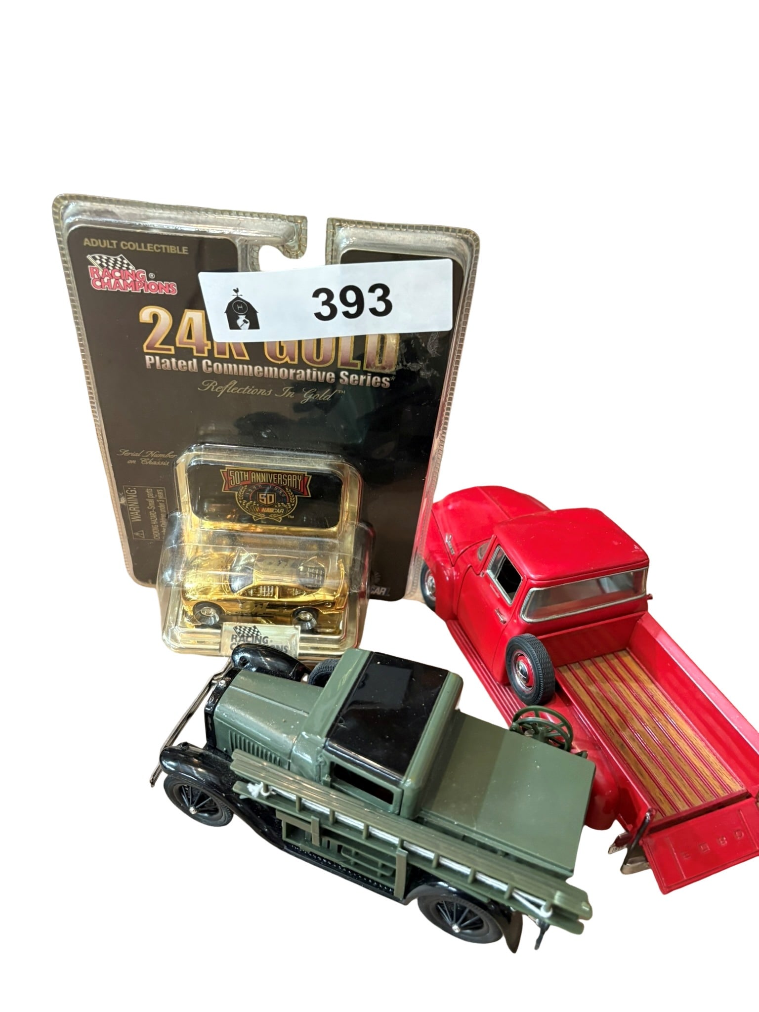 Diecast Vehicle Assortment Including Racing Champions 24K Gold NASCAR Edition: This lot features a curated collection of three distinct diecast vehicles, headlined by a Racing Champions 24K gold-plated NASCAR commemorative edition in its original sealed blister packaging. Also i