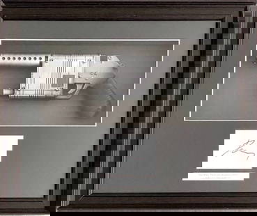 Star Wars - The Force Awakens, NN-14 Rey's Blaster Replica: Star Wars - The Force Awakens, NN-14 Rey's Blaster ReplicaNN-14 Blaster Replica with Daisy Ridley's autograph. Frame with a defect, otherwise in good condition, 37 x 43 x 5 cm.Réplique du blaster