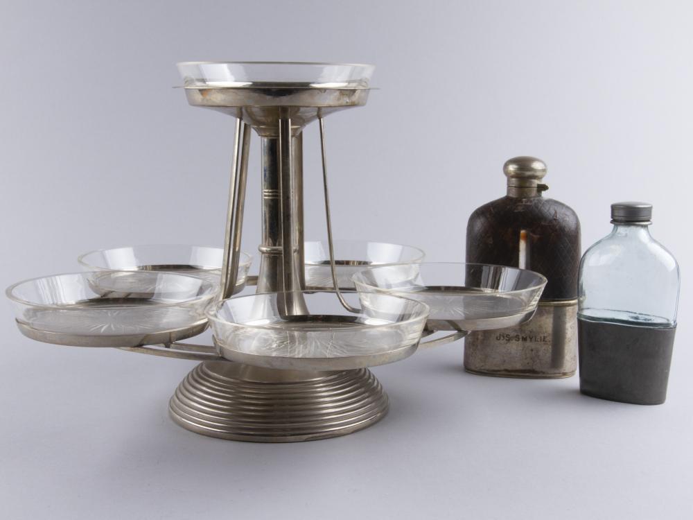 Serving Rack Jugend & Flasks 2 pcs: Rotating serving rack height 22.8 cm. One of the flasks tin and glass, height 13.5 cm. Other leather metal with a leather cover on the glass, J.S. Smylie, korkeus 16 cm. Condition Report: Normal wear