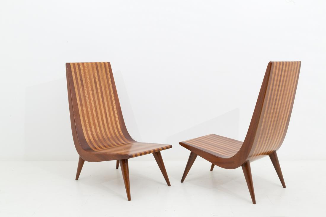 CARLOS DA COSTA. Pair of wooden armchairs: CARLOS DA COSTA. Coppia di poltrone in varie essenze di legno pregiato a listelli. Manifattura brasiliana. XX secolo. Mis. Lung. cm. 48 Alt. cm. 105 Prof. cm. 82 ca. Val. 3000/4000