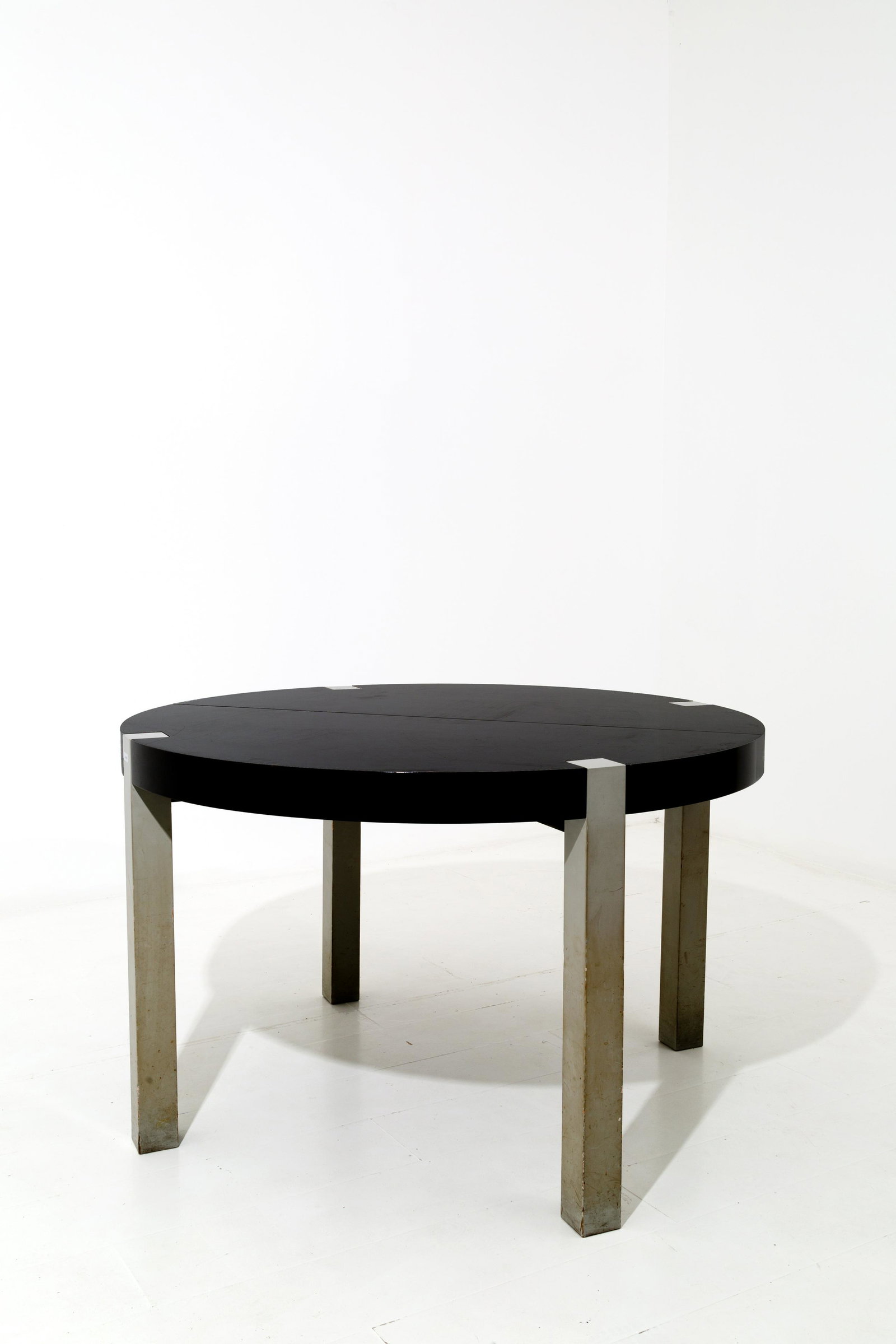 Italian extendable walnut table.: Tavolo da pranzo allungabile in legno laccato. Manifattura italiana. Anni '70. Mis. Alt. cm. 63 Diam. cm. 120 ca. Val. 1000/1500