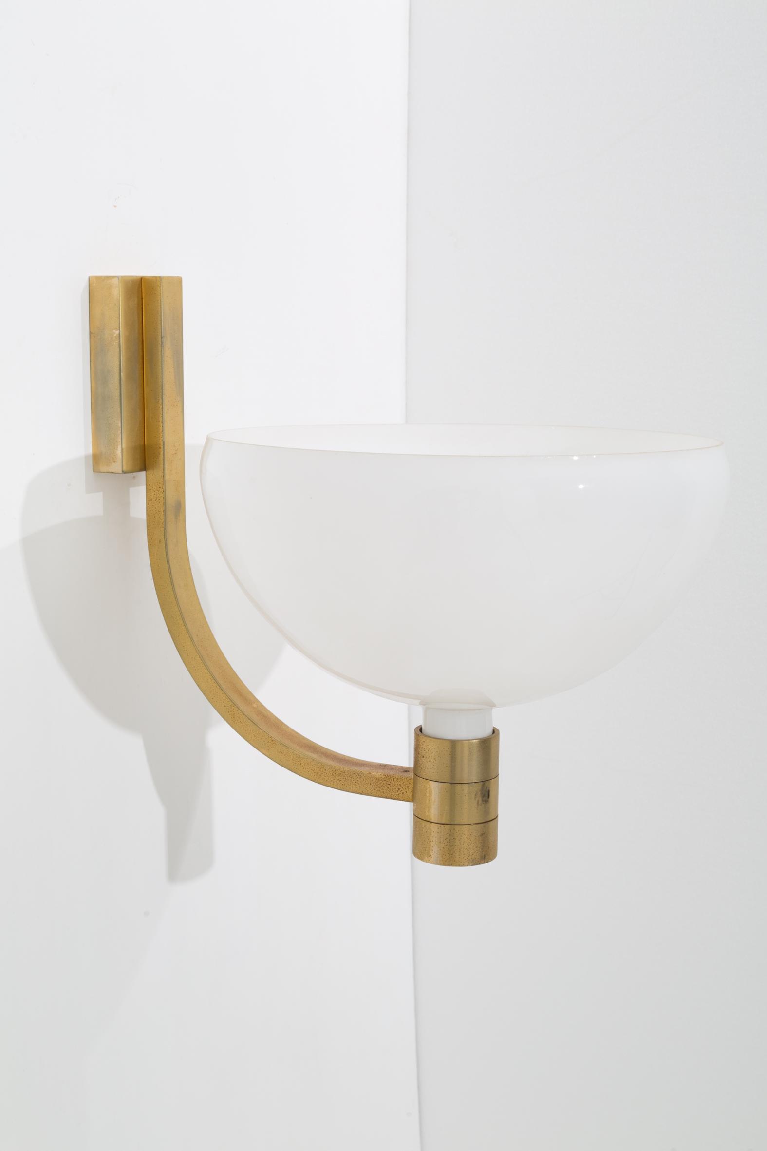 FRANCO ALBINI and FRANCA HELG. Wall lamp: FRANCO ALBINI (Robbiate, 1905 - Milano, 1977) e FRANCA HELG (Milano, 1920-1989). Applique in vetro bianco con braccio in bronzo dorato. Anni '60. Mis. Alt. cm. 50 Prof. cm. 50 Diam. cm. 36 ca. Val. 50