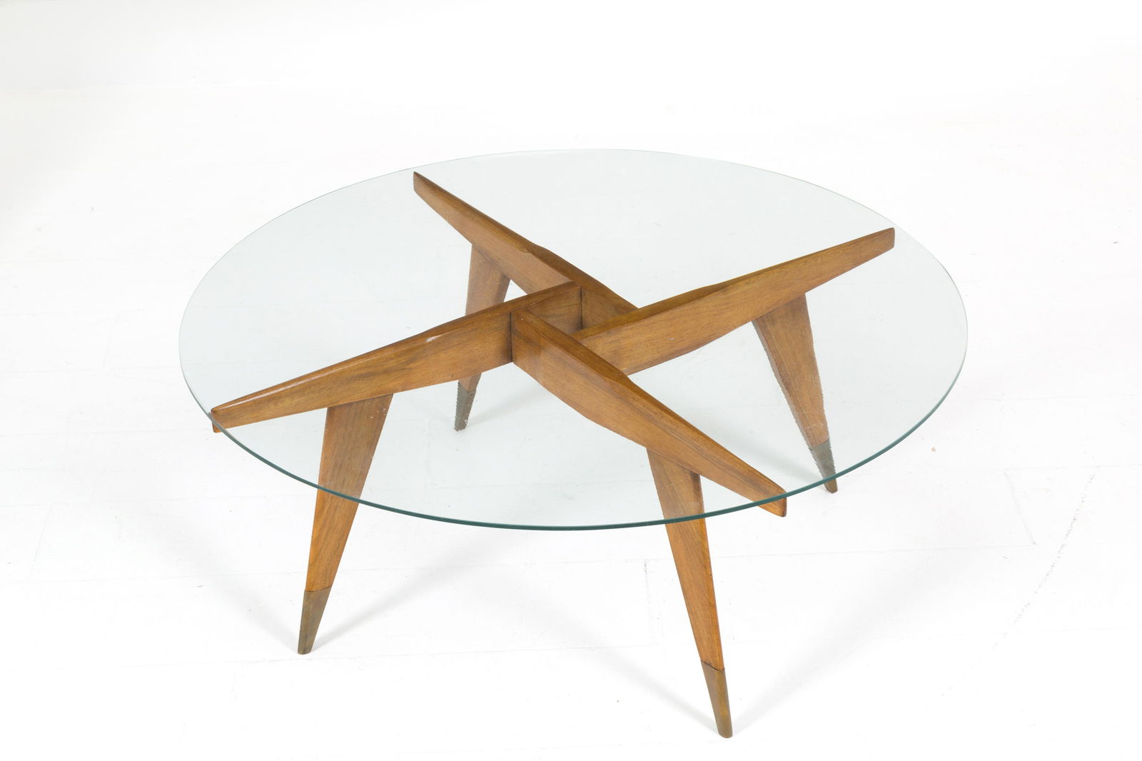 G. PONTI (Attr.) for SINGER AND SONS Coffee table: GIO PONTI (Attr.) (Milano, 1891-1979) per SINGER AND SONS. Tavolino in legno con puntali in ottone e piano circolare in vetro. Anni '50. Pubblicato sul catalogo del produttore. Esempi simili in R. Alo