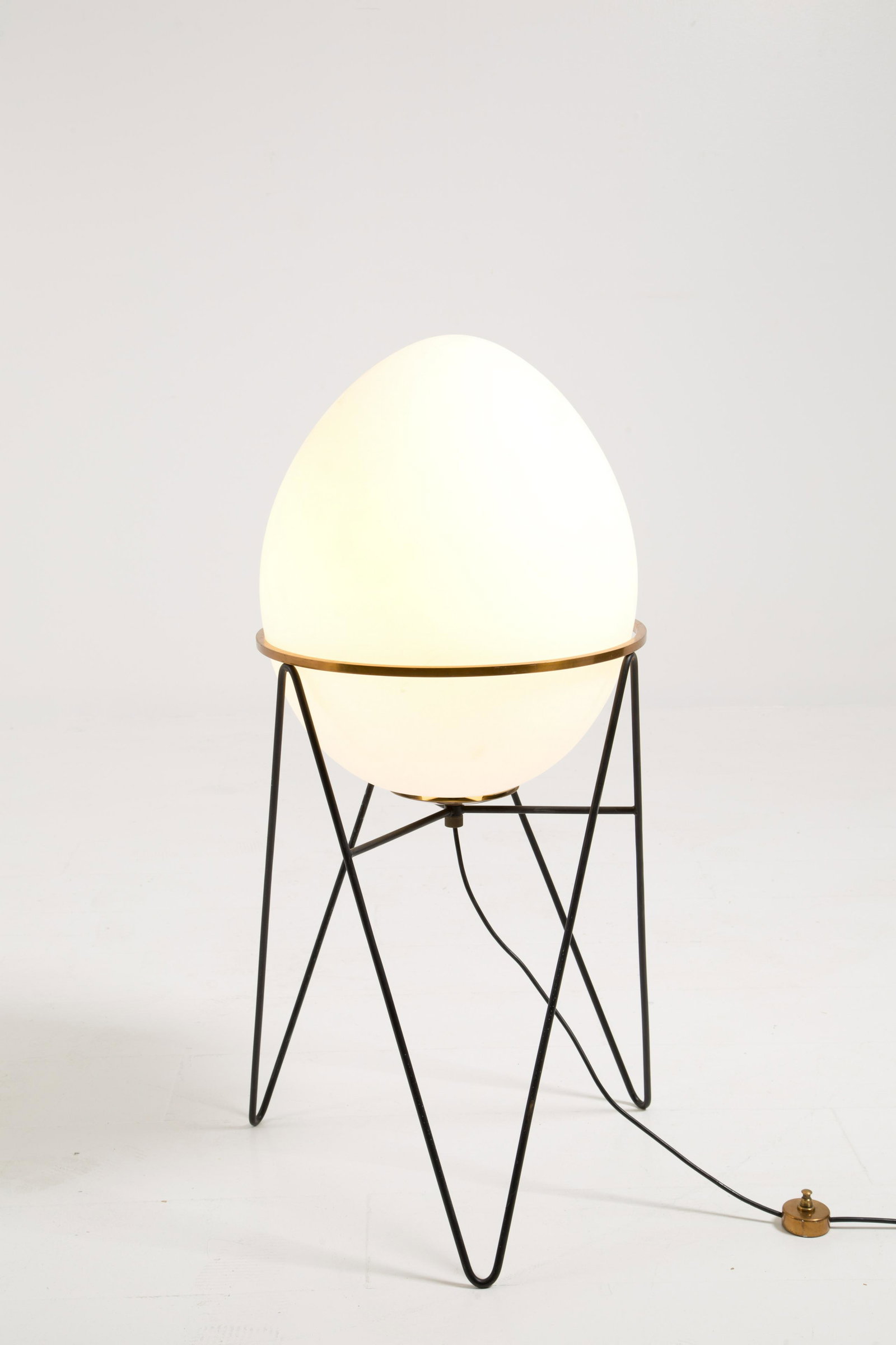 STILNOVO. Egg-shaped glass table lamp: Lampada da terra a forma di uovo in vetro con base in ferro e ottone. Produzione STILNOVO. Etichetta del produttore. Anni '50. Pubblicata. Difetti. Mis. Alt. cm. 95 Diam. cm. 50 ca.