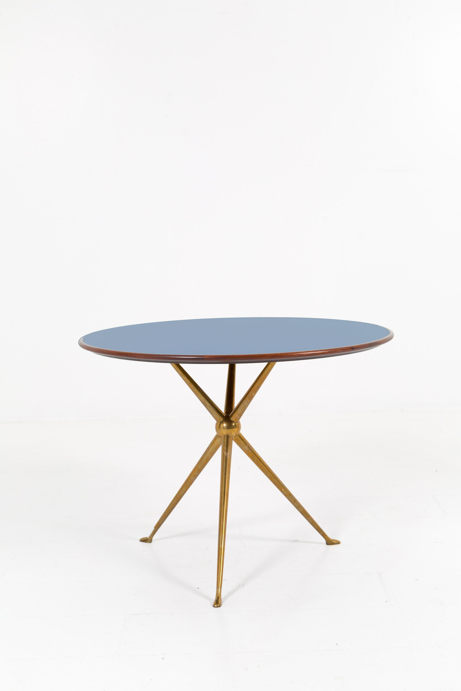 OSVALDO BORSANI. Brass table with glass top: OSVALDO BORSANI (Varedo, 1911 - Milano, 1985). Tavolo in ottone con piano in vetro retrodipinto azzurro. Anni '60. Ottime condizioni. Mis. Alt. cm. 53 Diam. cm. 70 ca.