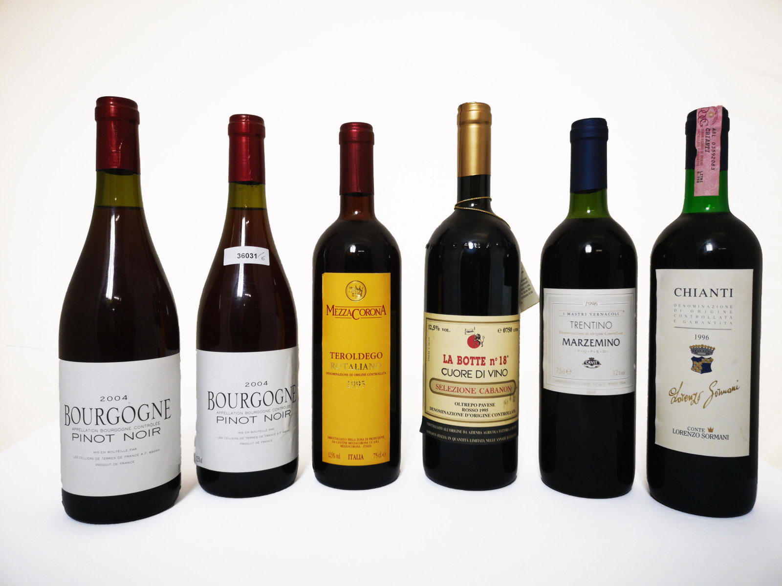 Six bottles of various red wine: Sei bottiglie di vino di cui due di Bourgogne Pinot Noir (2004), una di Oltrepo Pavese La Botte n. 18 (1995), una di Marzemino i Maestri Vernacoli (1996), una di Teroldego Rotaliano Mezzacorona (1995)