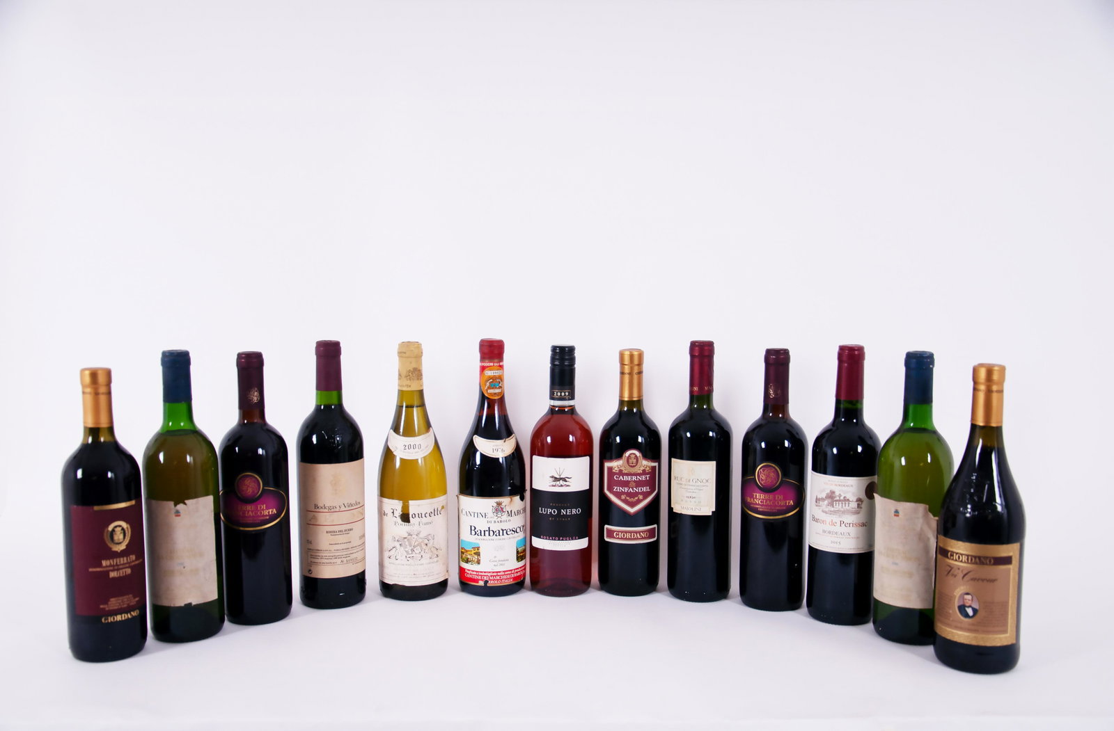 Thirteen different type of wines: Lotto composto da tredici bottiglie di vini vari. Val. 150/200Dettagliuna di Barbaresco, Cantine Marchesi (1976), due di Terre di Franciacorta (2003), una di Vei Cavour etichetta oro Giordano, una di 