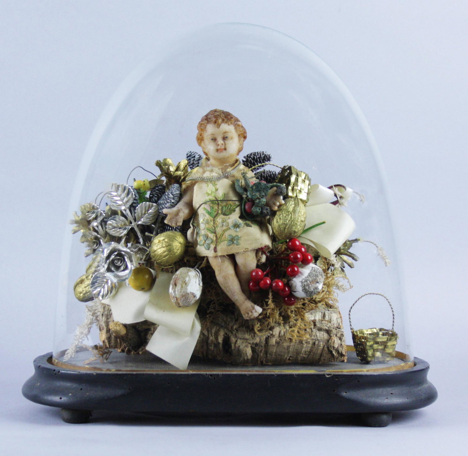Wax Christ Child sculpture under glass bell: Scultura in cera raff. ''BAMBIN GESU' '' su tronco in sughero con fiori e frutti. XX secolo. Sotto campana di vetro. Difetti. Mis. Alt. cm. 34 ca. Val. 150/250