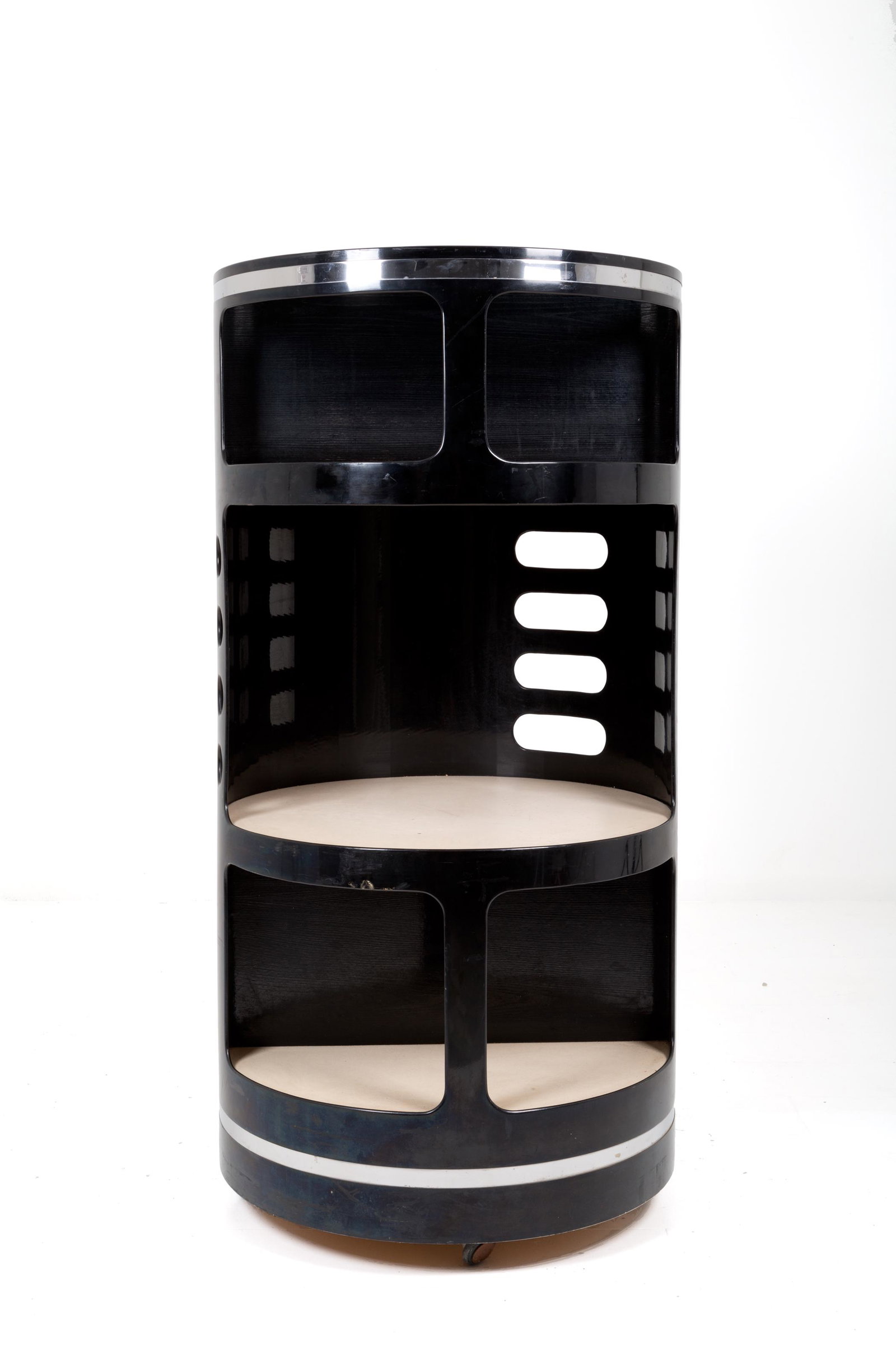 Circular bookcase in black lacquered wood. '70s: Libreria rotonda a sei scomparti in legno laccato nero e acciaio cromato con piani in similpelle color avorio. Manifattura italiana. Anni '70. Lievi difetti. Mis. Alt. cm. 140 Diam. cm. 70 ca. Val. 80