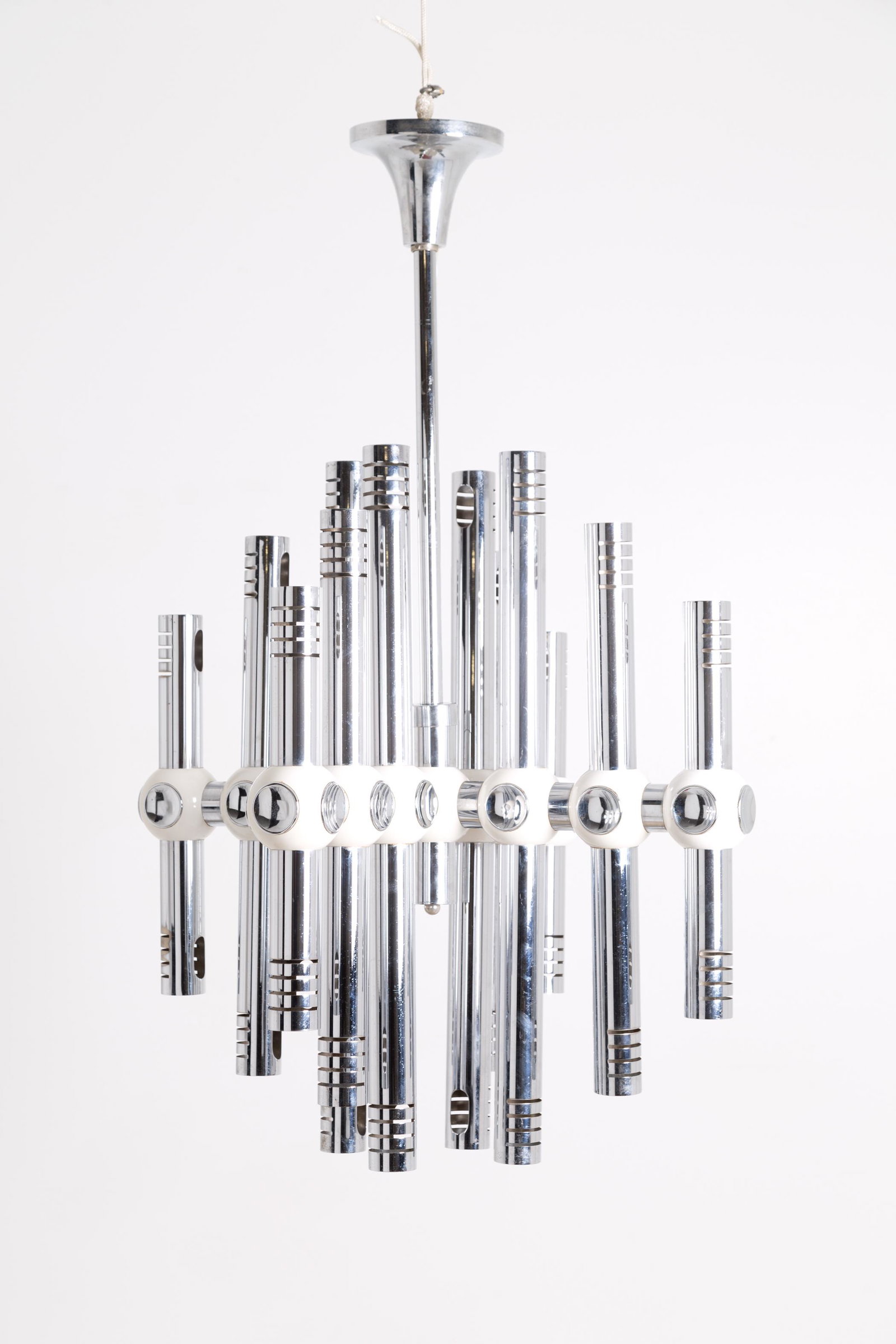 Chromed-steel chandelier. Italy. 1970s: Lampadario in acciaio cromato con tubi e raccordi bianchi. Manifattura italiana. Anni '70. Mis. Alt. cm. 96 Diam. cm. 90 ca. Val. 250/330