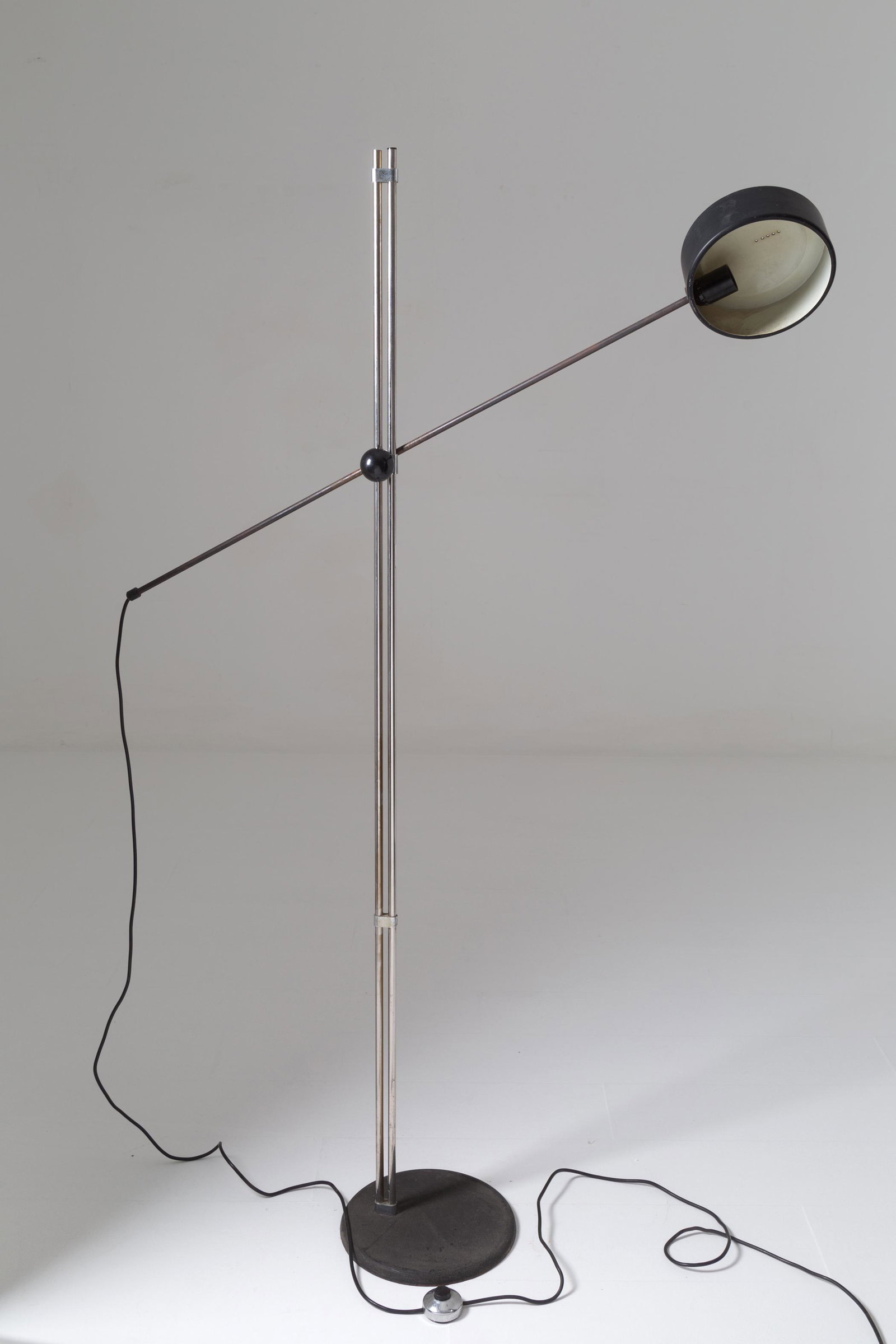 Tilting black-painted iron floor lamp. Italy. 70s: Lampada da terra in ferro verniciato nero con braccio basculante. Manifattura italiana. Anni '70. Mis. Lung. cm. 30 Alt. cm. 194 Prof. cm. 123 ca. Val. 300/400
