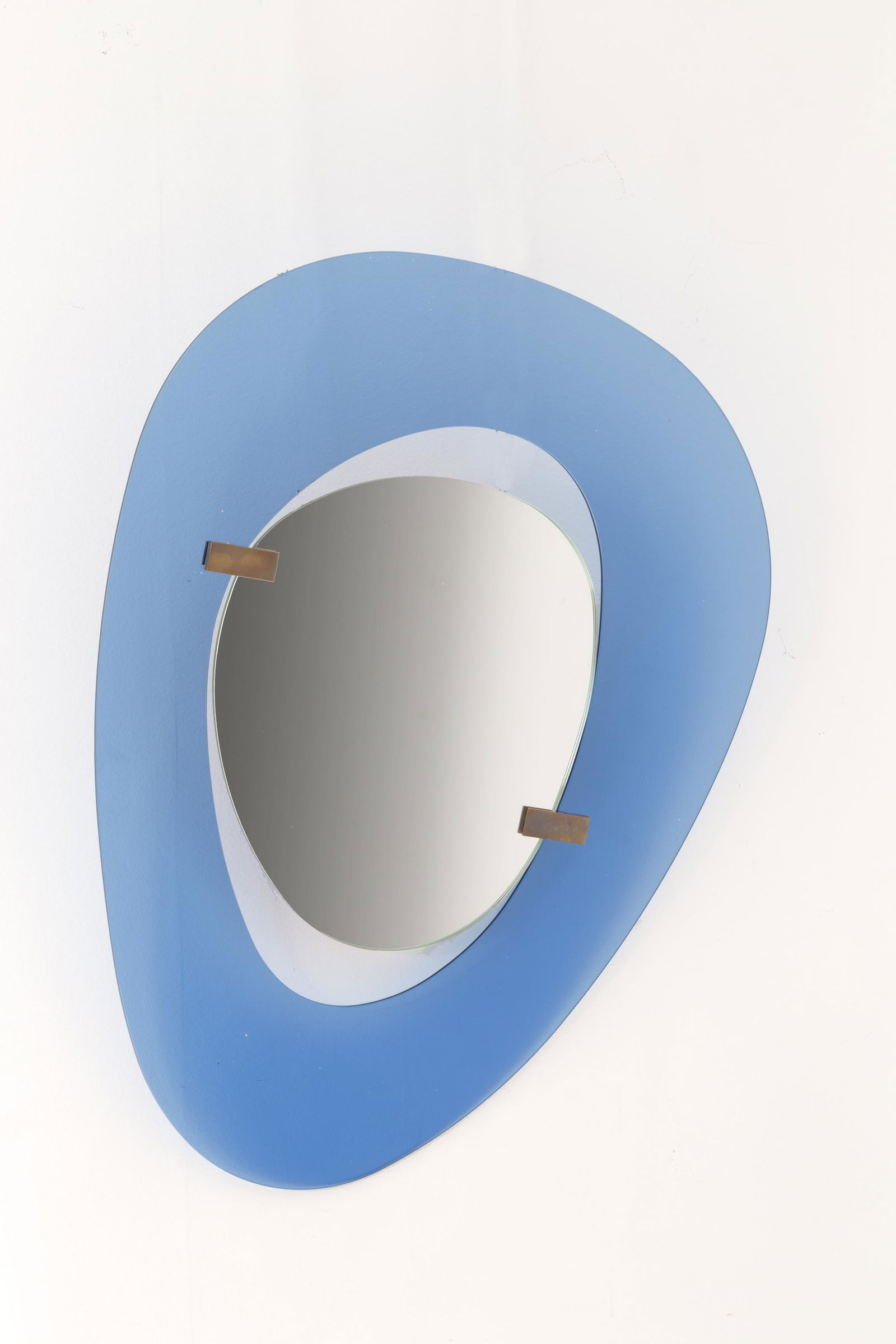 MAX INGRAND. Rare Fontanit mirror. FONTANA ARTE: MAX INGRAND (Bressuire, 1908 - Parigi, 1969) per FONTANA ARTE. Raro specchio Fontanit con cornice asimmetrica in vetro blu lucido e fermagli in ottone. Anni '50. Pubblicato in F. Deboni, Fontana Arte: