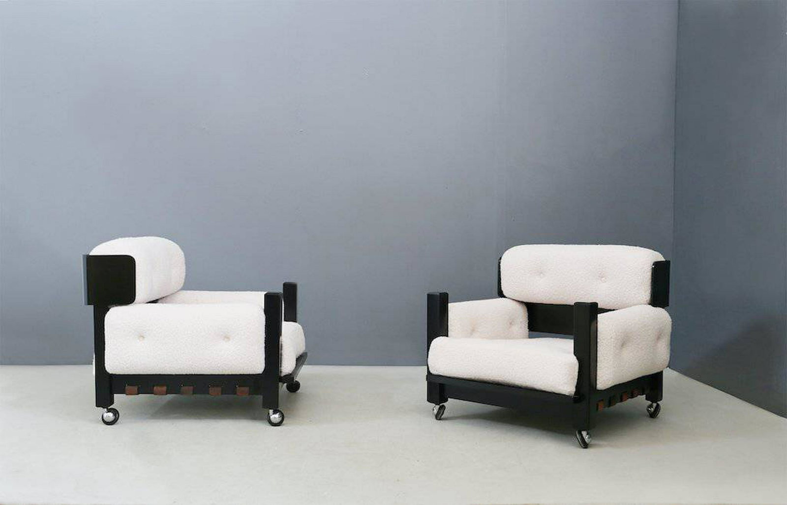 Two wooden armchairs. Italy. 1960s: Coppia di poltrone in legno e tessuto bouclé. Manifattura italiana. Anni '60. Restauri. Mis. Lung. cm. 87 Alt. cm. 70 Prof. cm. 87 ca. Val. 800/1000