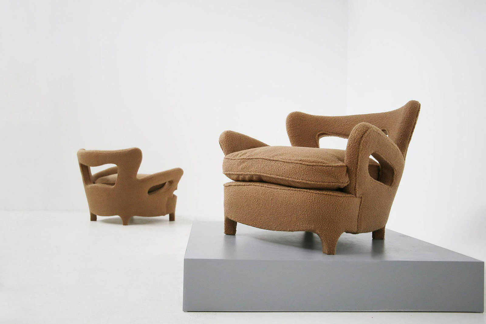 CARLO ENRICO RAVA (Attr.). Two unique armchairs. 1940s: CARLO ENRICO RAVA (Attr.) (Cernobbio, 1903 - Milano, 1986). Rara coppia di poltrone in legno e tessuto bouclÃ© marrone con schienale traforato e piedini sagomati. Anni '40. Rifoderate. Mis. Lung. cm