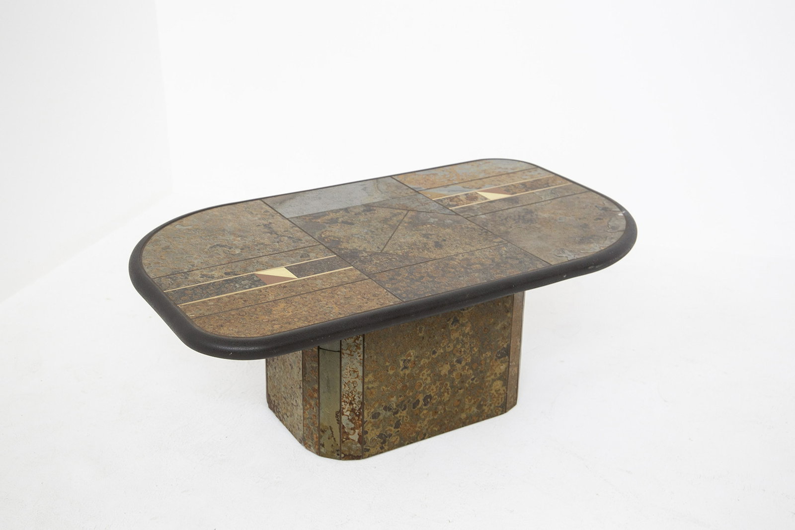 PAUL KINGMAN. Coffee tabel. 1970s: PAUL KINGMAN. Tavolino brutalista con piano in ardesia e pietra naturale con intarsi in rame e ottone. Anni '70. Mis. Lung. cm. 124 Alt. cm. 46 Prof. cm. 74 ca. Val. 500/600
