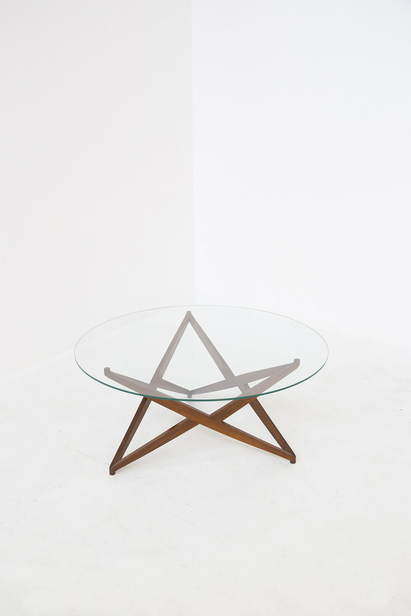 ANGELO OSTUNI. Unique coffe table. 1960s: ANGELO OSTUNI. Raro tavolino in legno con base a forma di stella e piano in vetro. Anni '60. Mis. Alt. cm. 45 Diam. cm. 100 ca. Val. 7000/9000