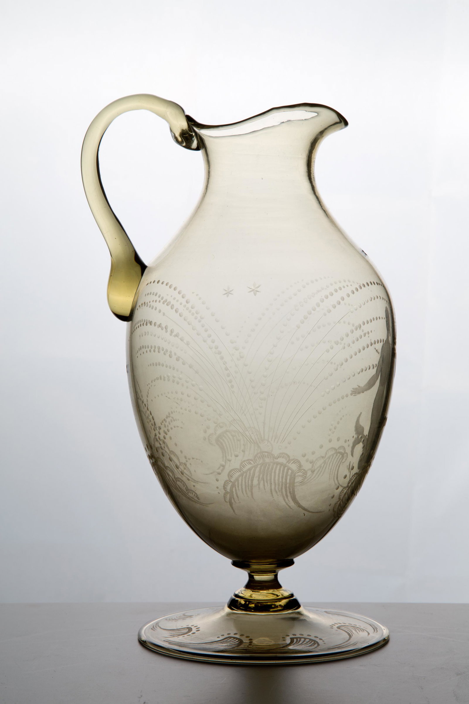 GUIDO MARIA BALSAMO STELLA. Glass pitcher: GUIDO MARIA BALSAMO STELLA (Torino, 1882 - Asolo, 1941). Brocca in vetro. Mis. Lung. cm. 16 Alt. cm. 26.5 Diam. cm. 14 ca. Val. 1400/2000