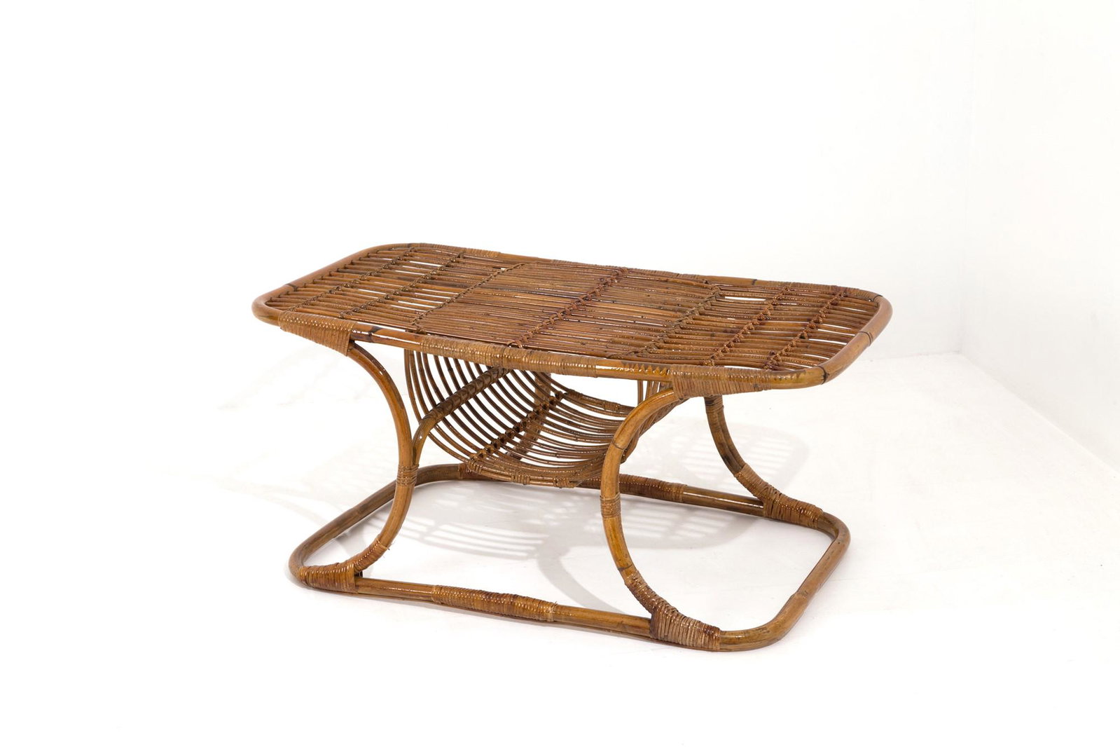 TITO AGNOLI (Lima 1931-Milano 2012). Coffee table: Coffee table with wicker magazine rack. 70's.47x105x57 cm approx. Tavolino con portariviste in midollino. Anni '70.