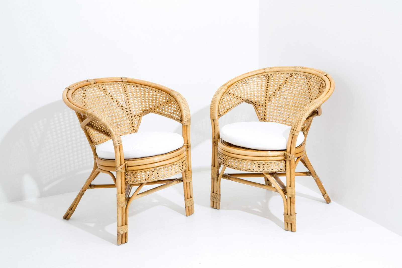 Pair of armchairs: Pair of bamboo armchairs with straw seat and back and removable cushions in white fabric. Italian manufacture. 1950s. 75x65x65 cm approx. Coppia di poltrone in bambu' con seduta e schienale in paglia 