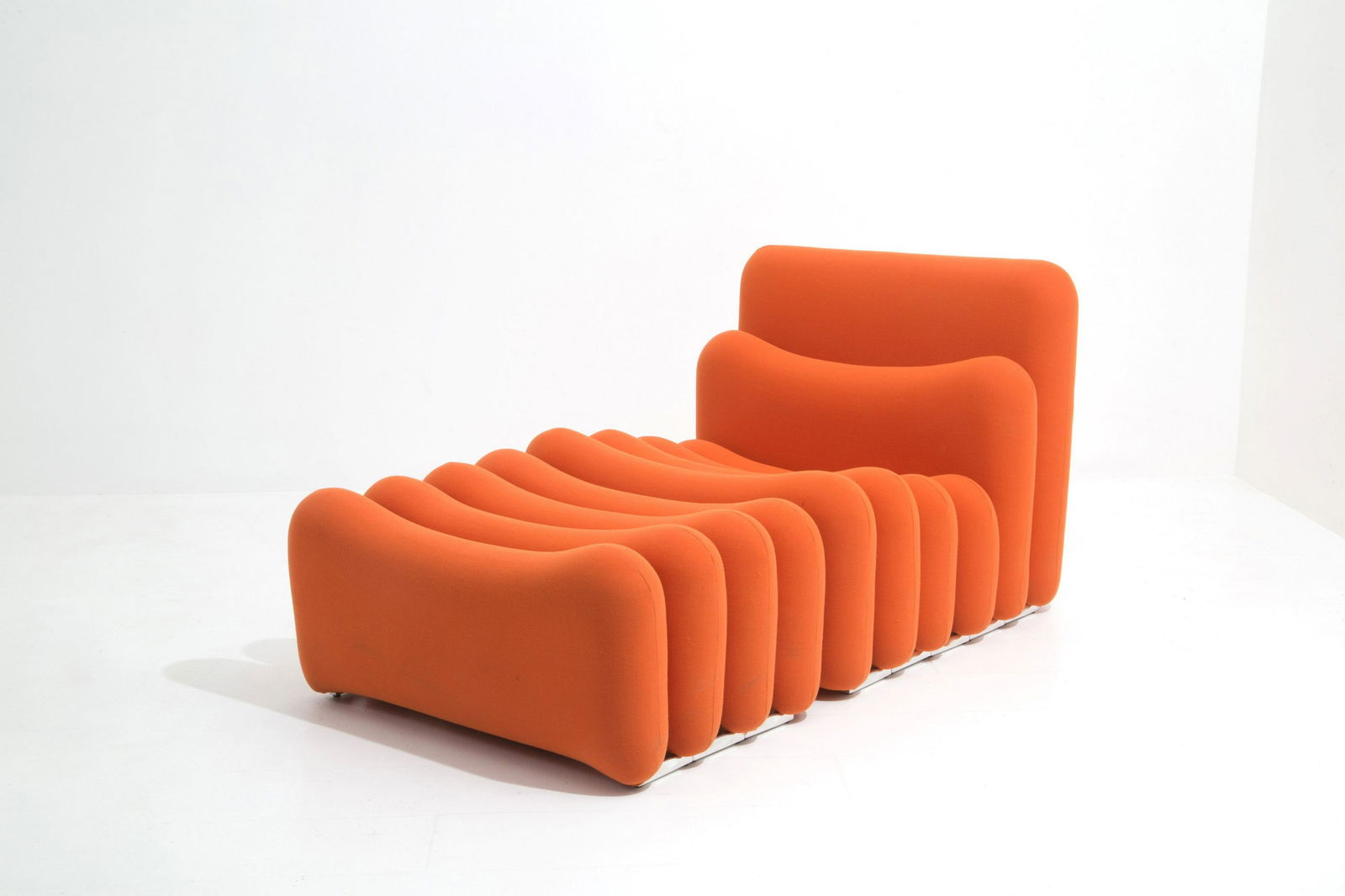 JOE COLOMBO. Additional System armchair with pouf for SORMANI: Armchair with Additional System pouf in aluminum and lobster-colored fabric. SORMANI production. With manufacturer's mark. 1970s. Mis. armchair length cm. 75 Height cm. 67 Depth cm. 78 Mis. pouf Lengt