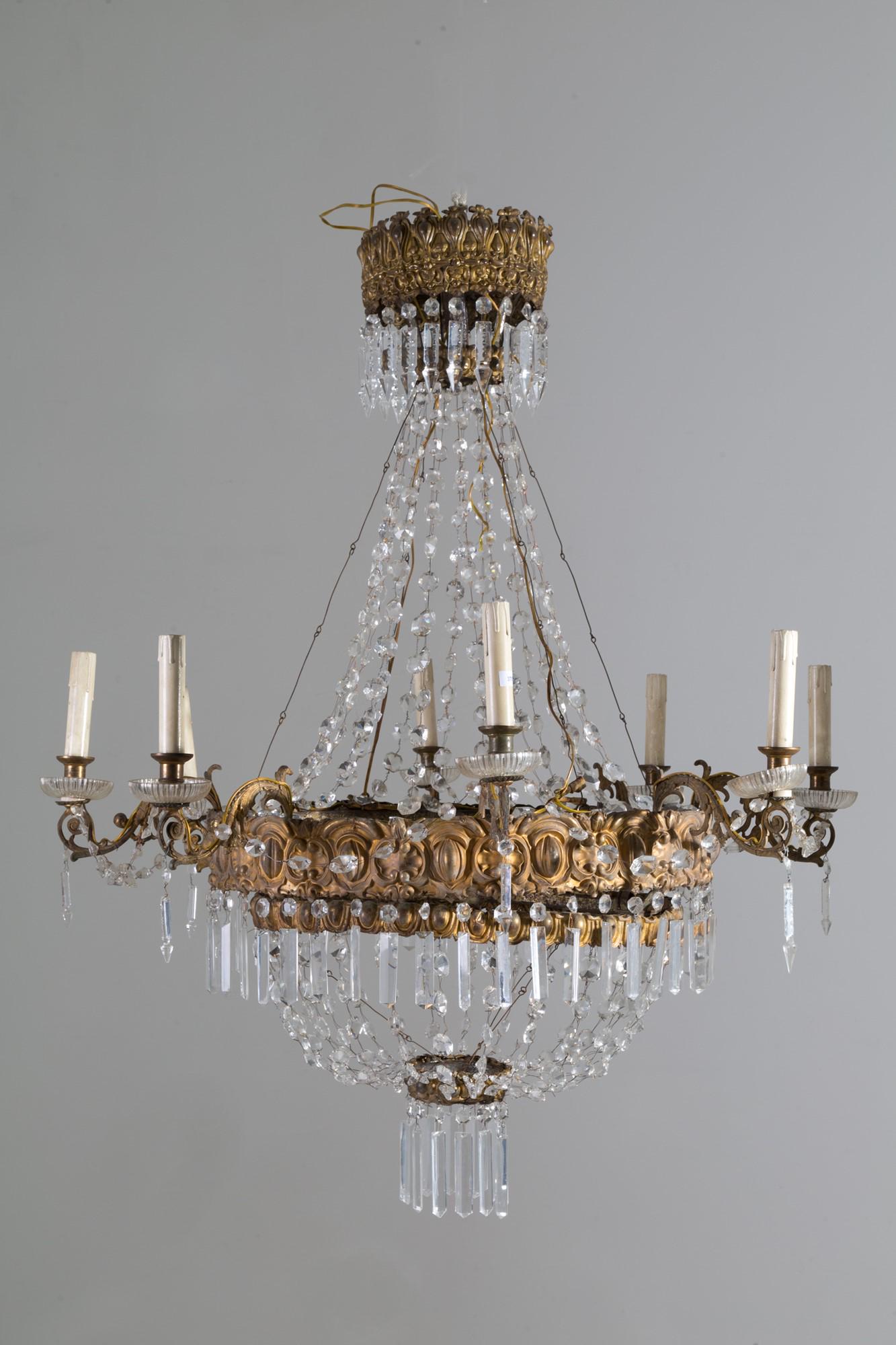 Gilded bronze chandelier: Eight-arm chandelier in embossed and gilded sheet metal with ground glass pendants and drops. Tuscany. Early 19th century. Defects and shortcomings. Height approx. 120 cm. Lampadario otto bracci in la