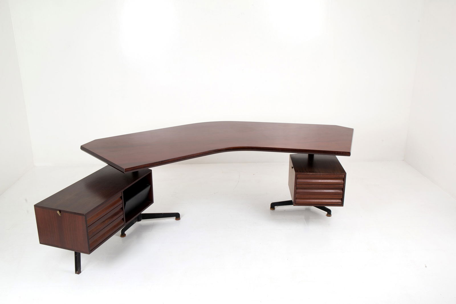 OSVALDO BORSANI. T96 "Boomerang" desk for TECNO: OSVALDO BORSANI (Varedo 1911-Milano 1985). Curved executive desk model T96 "Boomerang" in wood and steel with two adjustable drawers and removable basket. TECNO production. Late 60s. Slight defects an