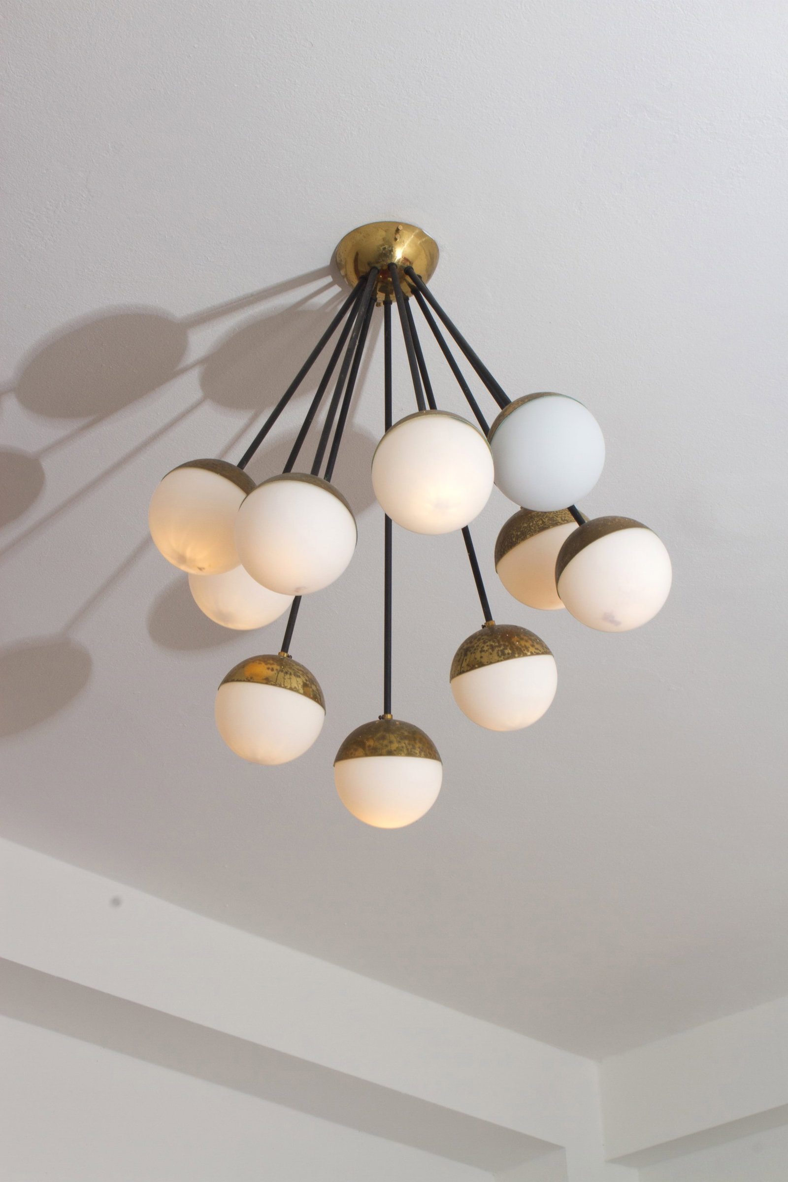 Galassia ten-light pendant lamp. STILNOVO: Galassia model pendant lamp in black painted tubular metal and brass with ten opaline glass diffusers. STILNOVO production. 1950s. Defects and signs of wear over time. 56x55 cm approx. Lampada a sospe