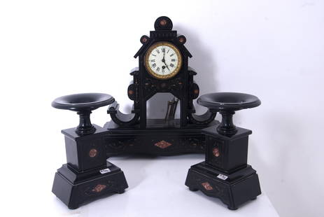 Triptych: Triptych comprising a clock (approx. 47 cm high) and two stands (approx. 27 cm high) in black marble with engraved and gilded decorations, pink marble inserts, and bronze finishes. 19th century. Minor