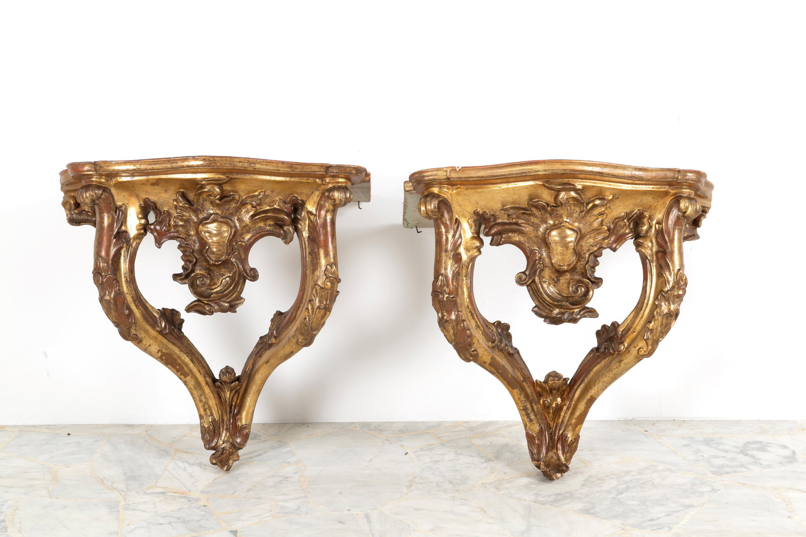 Pair of consoles: Pair of carved and gilded wooden console tables with faux marble tops. Naples. 18th century. Minor defects. 64x64x44 cm approx. Coppia di consolle in legno intagliato e dorato con piano in finto marmo