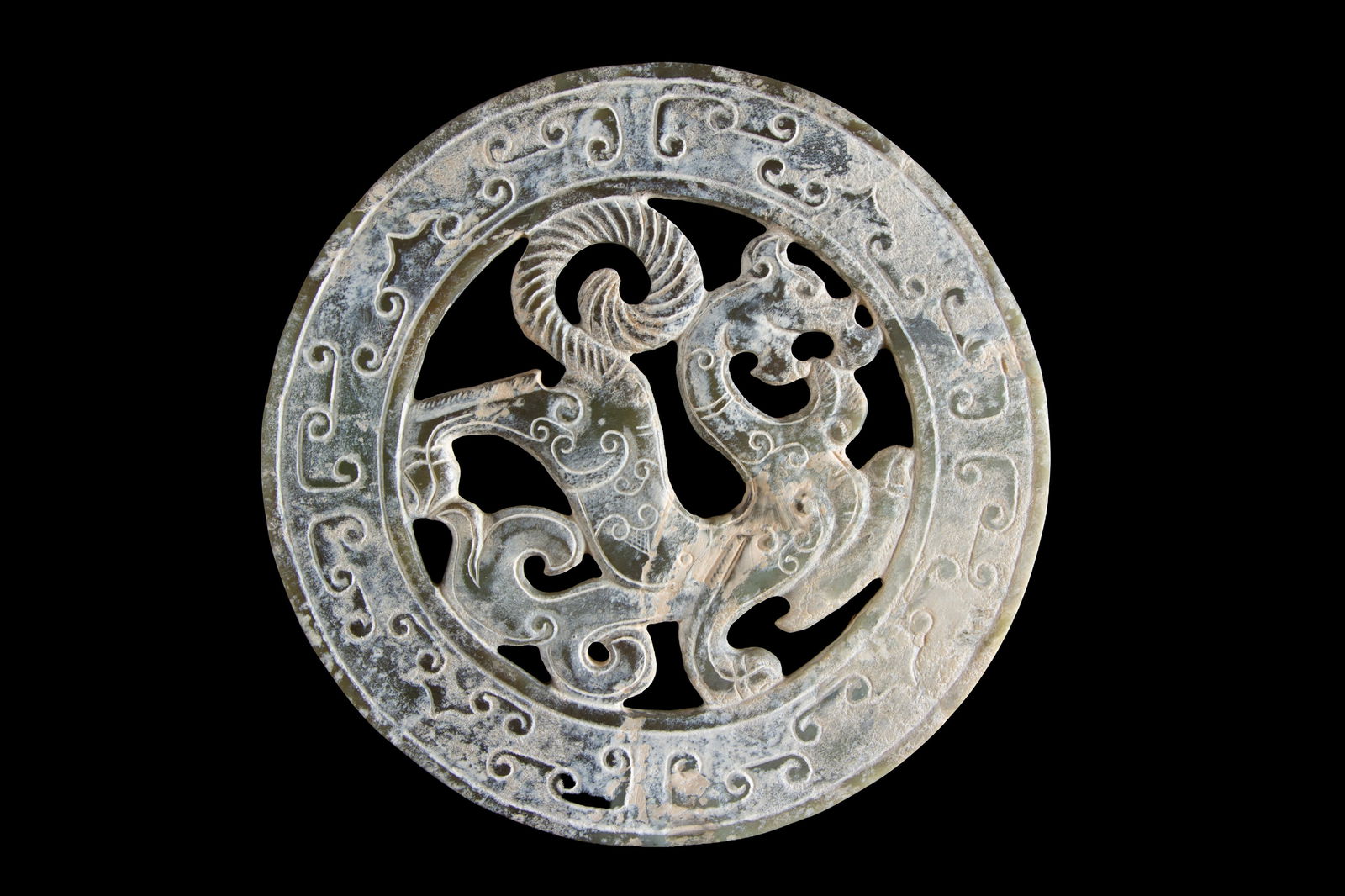 Perforated jade disc "DRAGON": A carved and perforated jade disc depicting a "DRAGON." China. Diam. 15 cm approx. Disco in giada traforata e intagliata raffigurante "DRAGO". Cina. Diam. 15 cm ca.