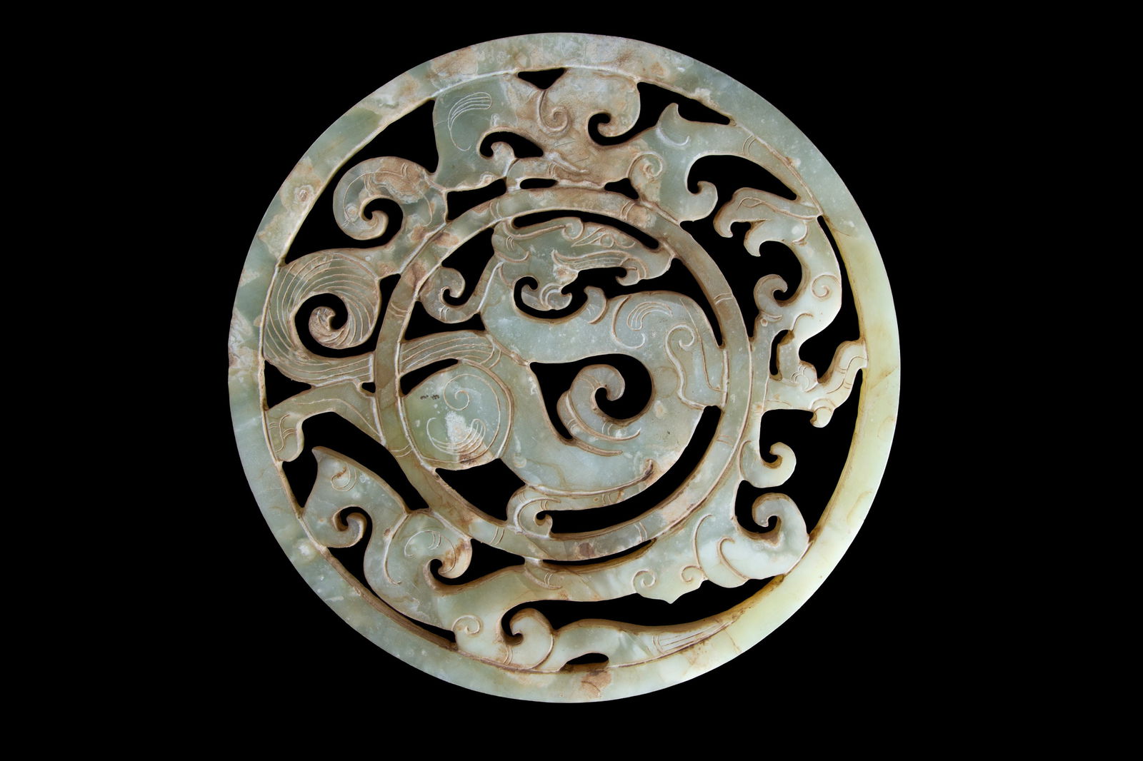 Jade pendant with dragon and phoenix: A jade pendant carved and pierced with a dragon motif on the inner ring and a phoenix facing it on the outer ring. China. Diam. 18 cm approx. Ciondolo in giada? traforata e intagliata con motivi