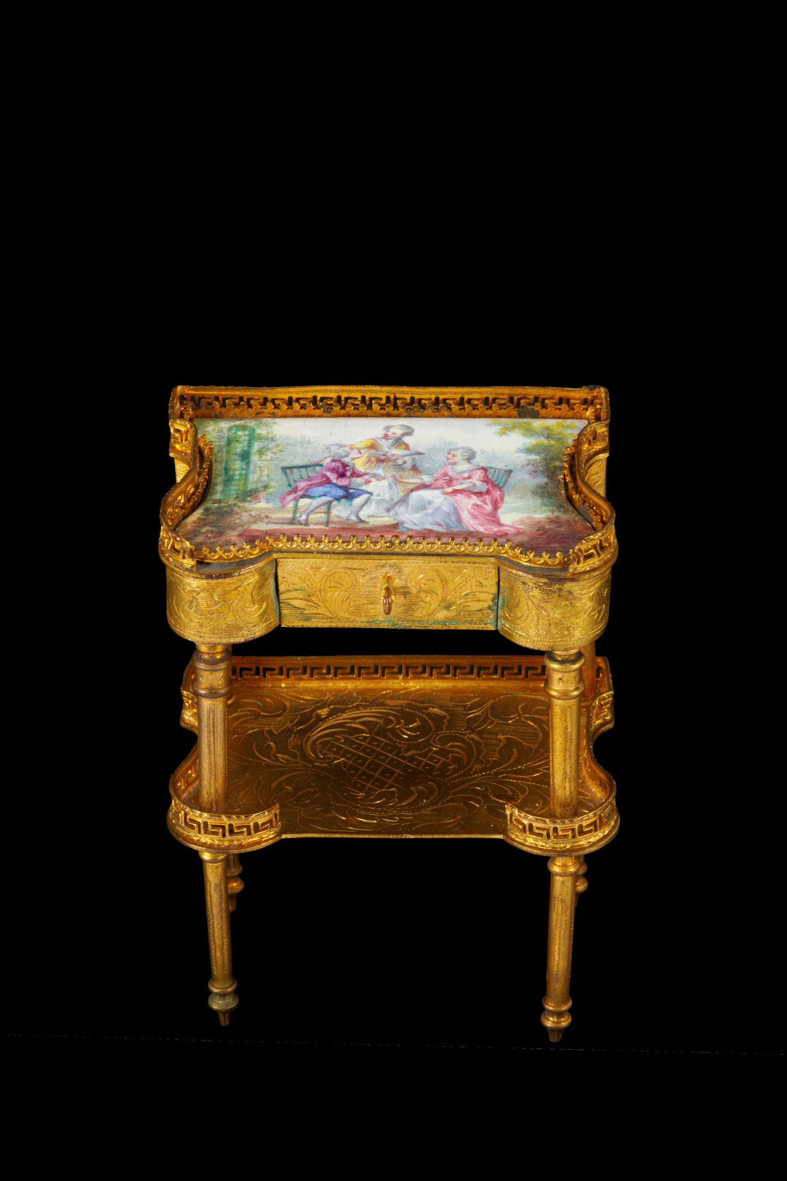 Model of a brass console table: Model of a console table with a drawer in finely chased, gilded, and enameled brass with romantic scenes. Vienna. Second half of the 19th century. 9.5x7x5 cm approx. Modellino di consolle con cassetto