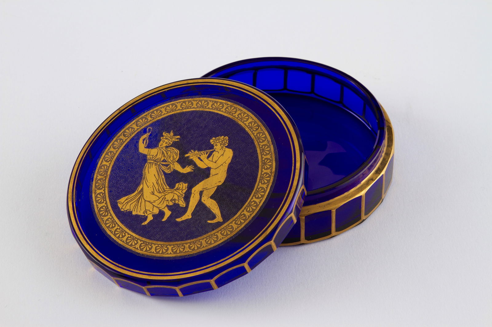 Blue and gold glass box: Blue glass box with gold decorations and a bacchanalian scene on the lid. Signs of wear. 4x12 cm approx. Scatola in vetro blu con decori oro e scena di baccanale sul coperchio. Segni di usura del