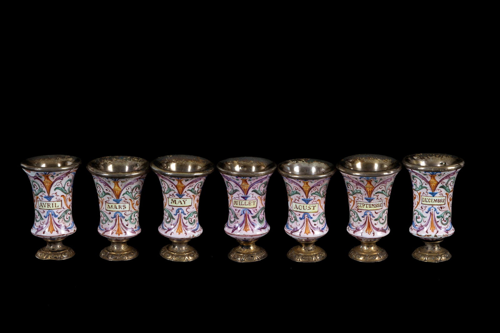 Seven models of silver goblets: Seven model silver chalices painted with the months of the year. France. 19th century. Minor defects. Height approx. 4.5 cm. Sette modellini di calici in argento dipinti con mesi dell'anno. Francia.
