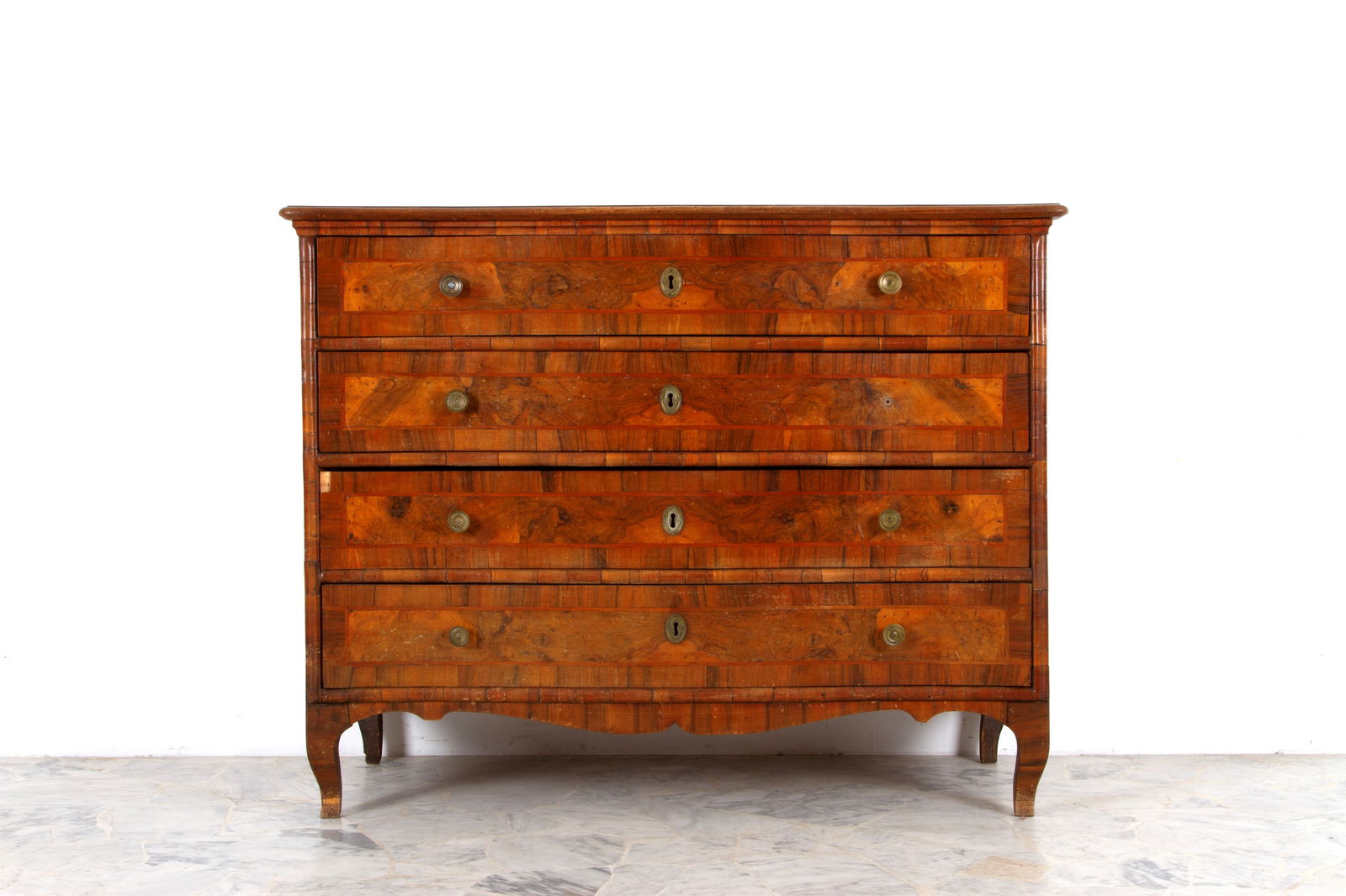 Veneered chest of drawers: Chest of drawers with a curved front, veneered in various woods, and four drawers. 18th century. Defects and missing parts. 105x134x58 cm approx. Com? mosso sul fronte lastronato in legni vari con