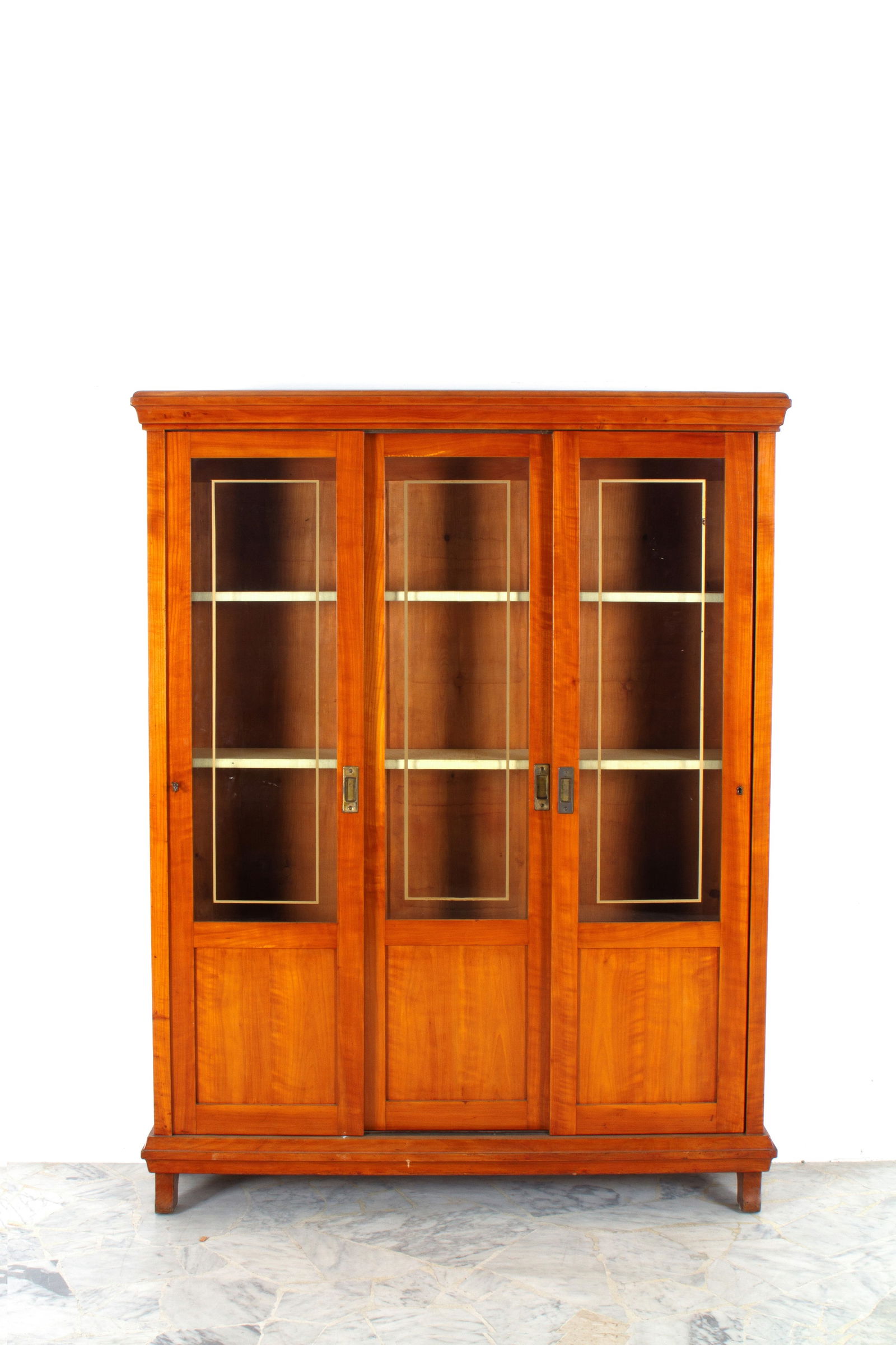 Wooden display cabinet: Wooden display cabinet with three sliding doors and shelves. Early 20th century. Minor defects. 177x137x34.5 cm approx. Vetrina in legno a tre ante scorrevoli con ripiani. Inizi XX secolo. Lievi difet
