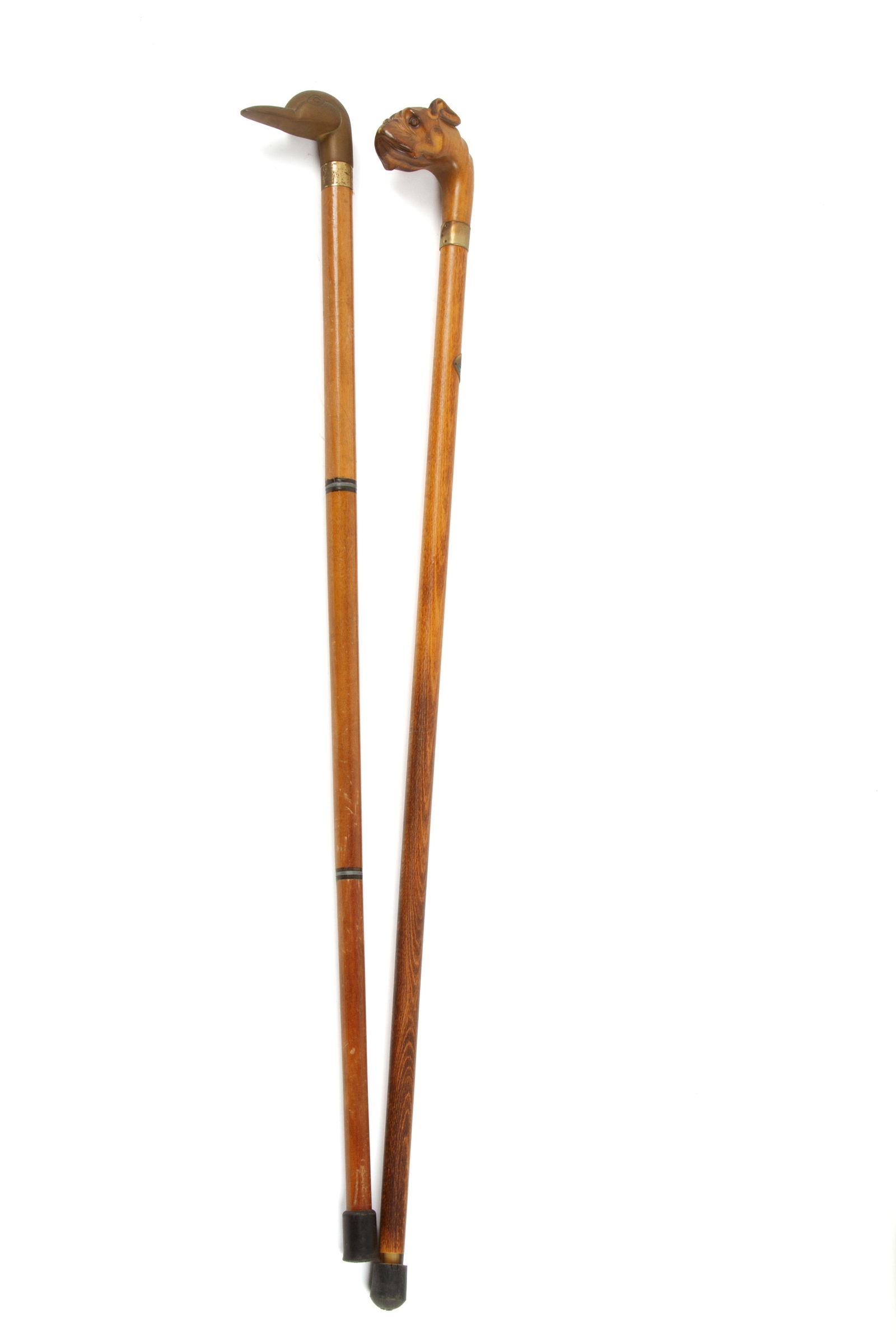 Two sticks with boxer and duck face handles: Two beech canes with handles shaped like a boxer's face and a duck's face. 20th century. Defects. Due bastoni in faggio con manico a forma di muso di boxer e di papera. XX secolo. Difetti.