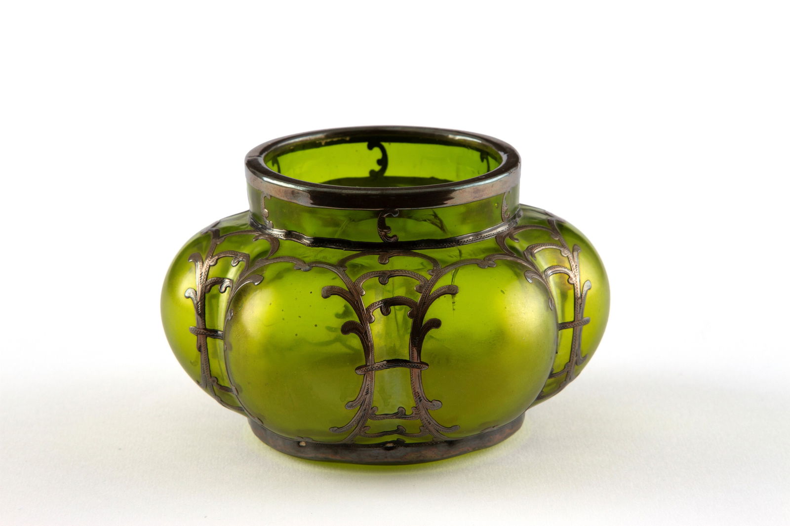 Vase with silver trimmings. LOETZ: Iridescent glass vase in shades of green, with silver trim. LOETZ manufacture. 7.5x12 cm approx. Vaso in vetro iridescente nei toni del verde, con guarnizioni in argento. Manifattura LOETZ. 7,5x12 cm