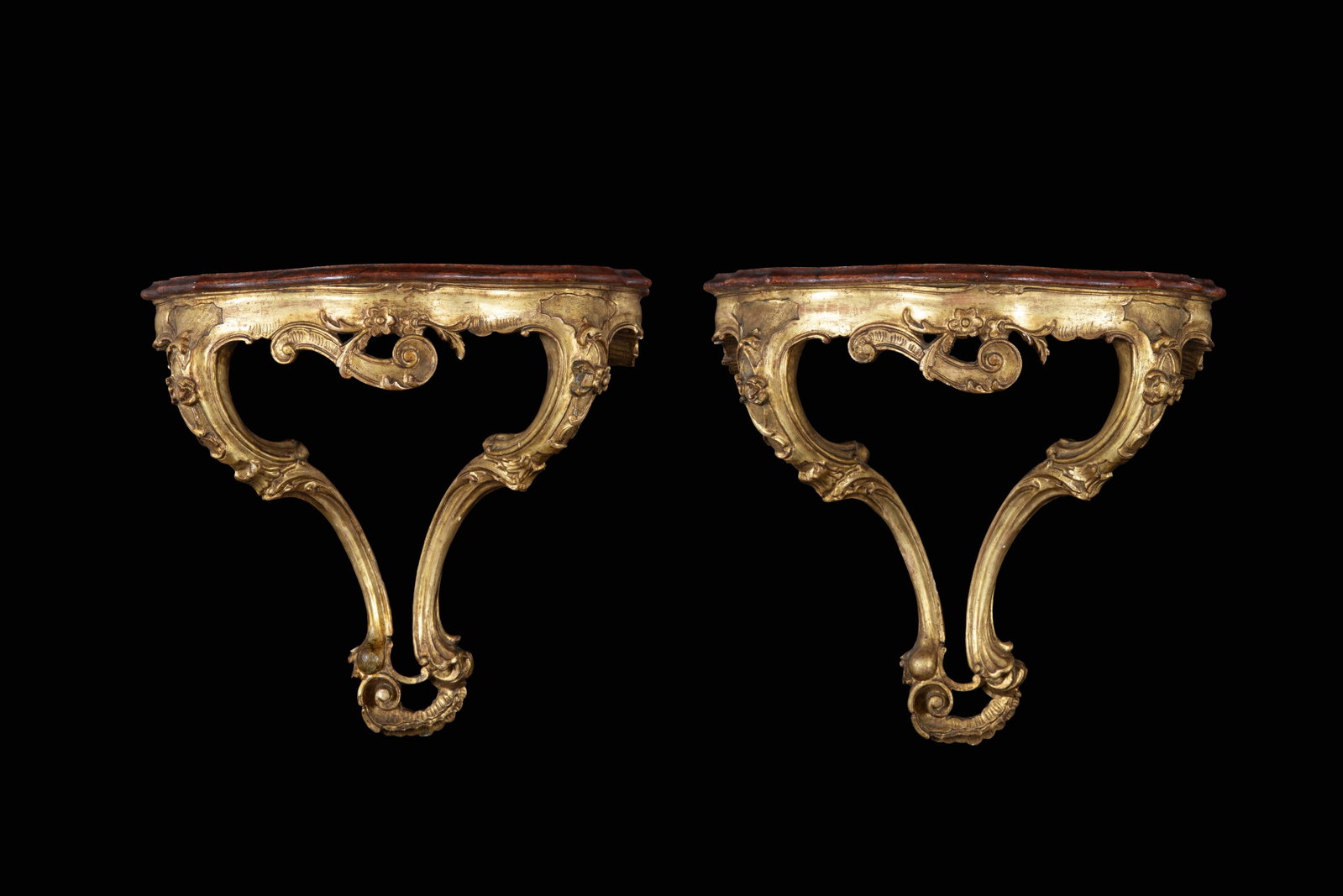 Coppia di consoline a goccia: Pair of carved and gilded wooden teardrop console tables with faux marble lacquered tops. 19th century. Minor defects. 53x57x33 cm approx. Coppia di consoline a goccia in legno intagliato e dorato con