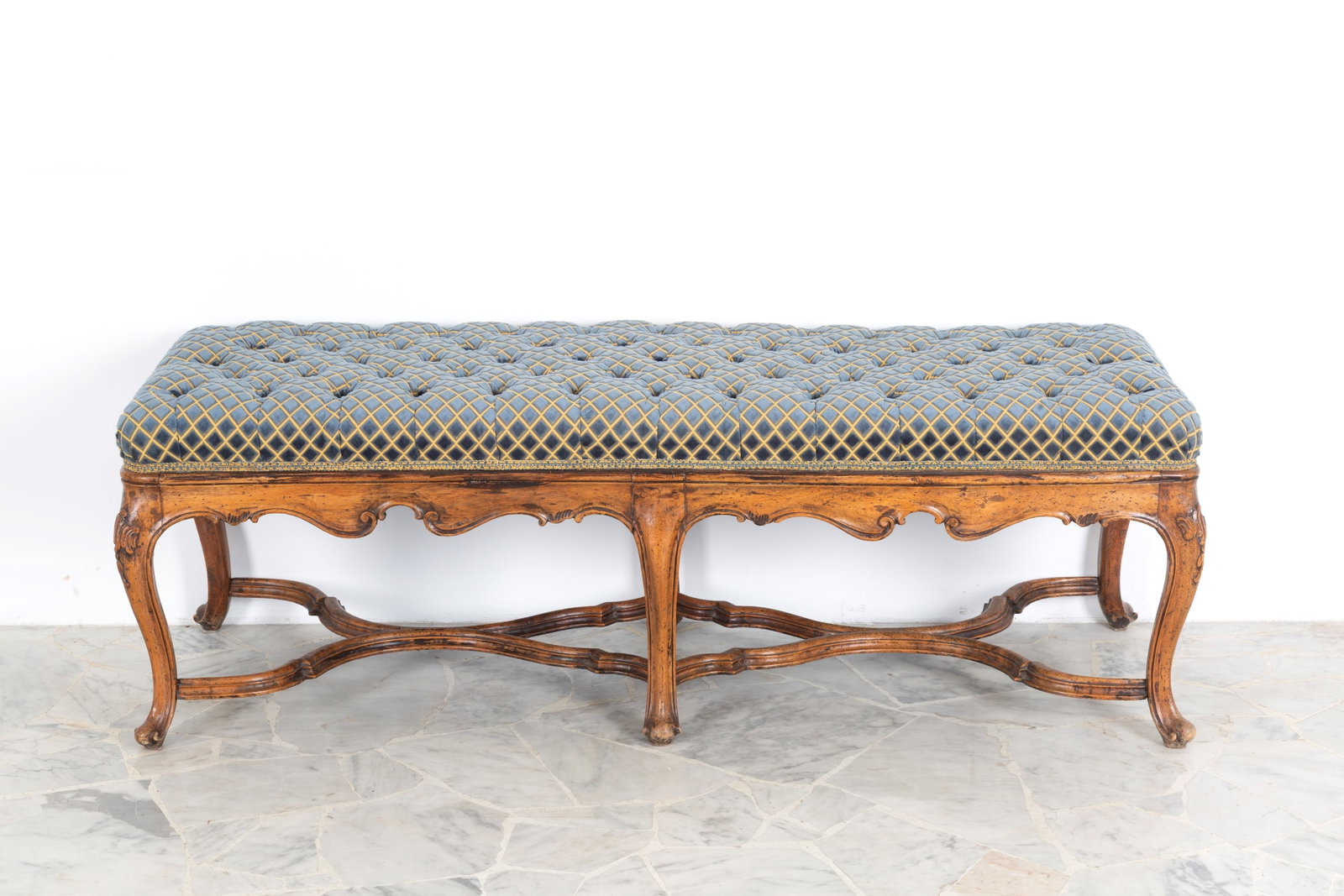 Panca in legno: Carved wooden bench with legs joined by crosspieces and a cotton seat. Lombardy-Veneto area. Louis XV period. Minor defects. 47x140x51 cm approx. Panca in legno intagliato con gambe unite da crociere 