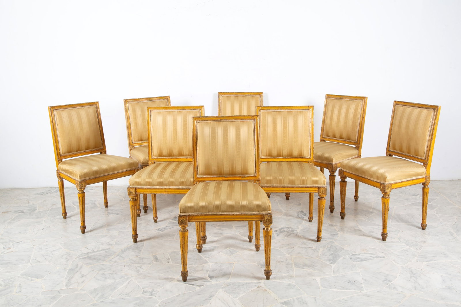 Otto sedie: Eight lacquered and gilded wooden chairs with tapered legs and padded seats and backs upholstered in satin. 19th century. Minor defects. 90x52x44 cm approx. Otto sedie in legno laccato e dorato con