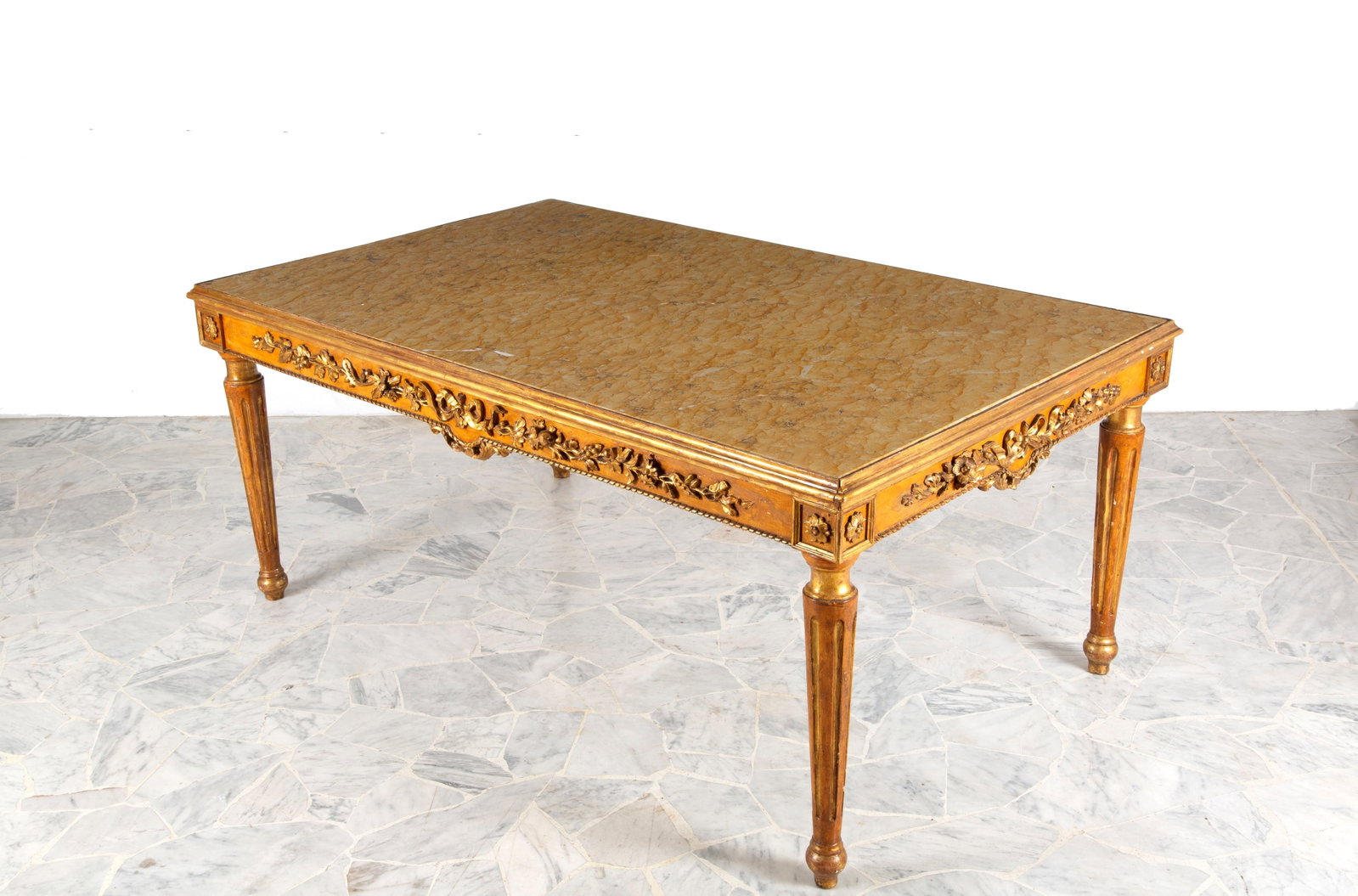 Tavolo con piano in marmo: Lacquered and gilded wooden table with embossed floral motifs, yellow marble top and tapered legs. 19th century. Minor defects. 80x183x114 cm approx. Tavolo in legno laccato e dorato con decori a