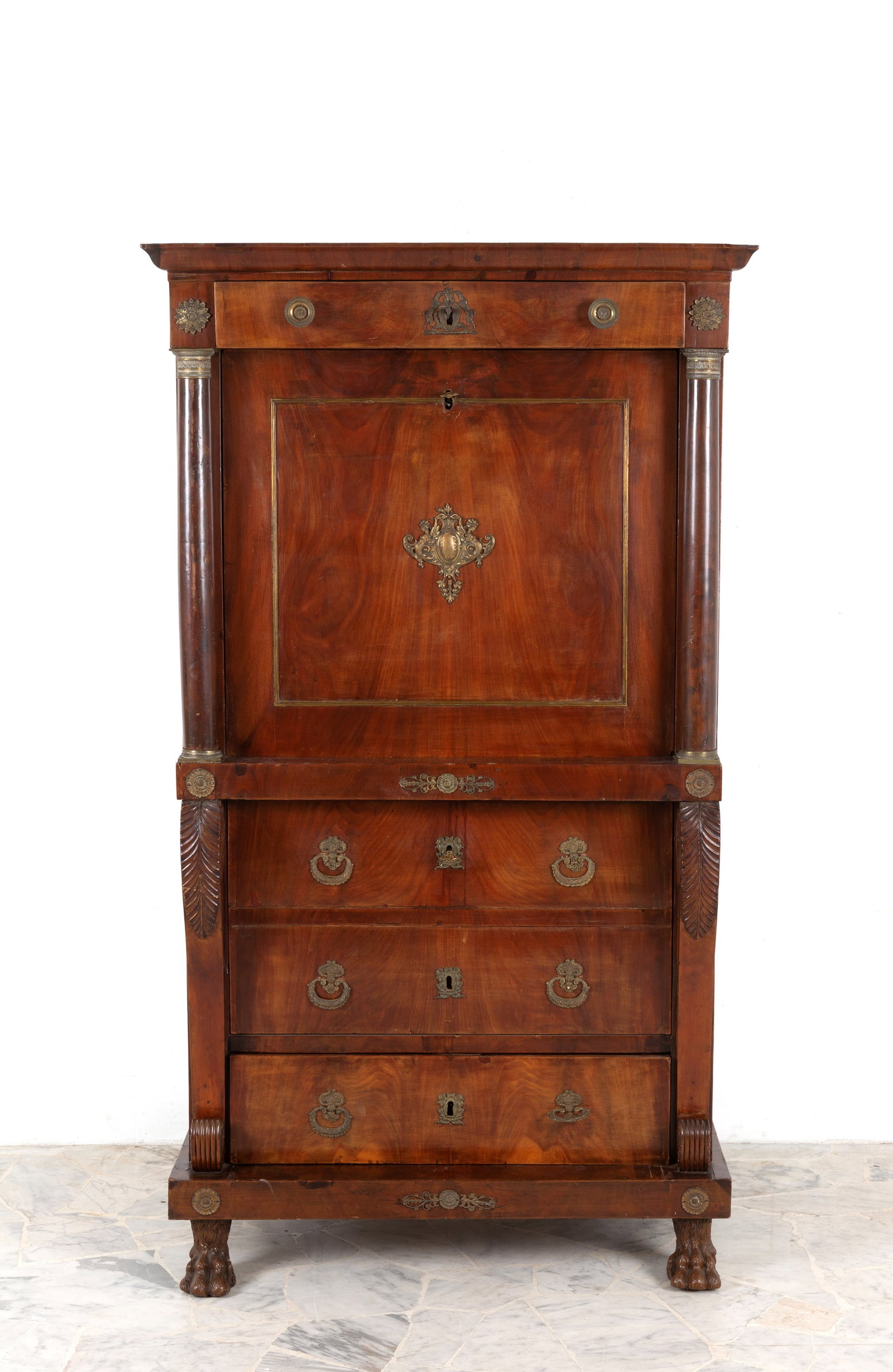 Secretaire: Mahogany veneered secretary with gilded bronze trim, carved wooden columns and pilasters, lion's feet, two drawers and two drop-down doors with drawers and secret compartments. 19th century. Minor