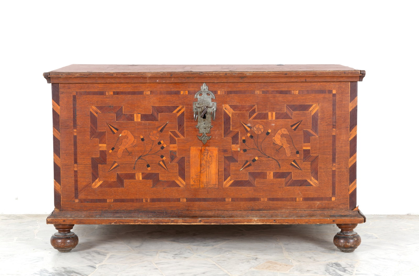 Cassone da viaggio: Travel chest inlaid with various woods and geometric motifs with floral decorations, birds and wrought-iron handles on the sides. Northern Europe. Last quarter of the 17th century. Defects. 67x115x66